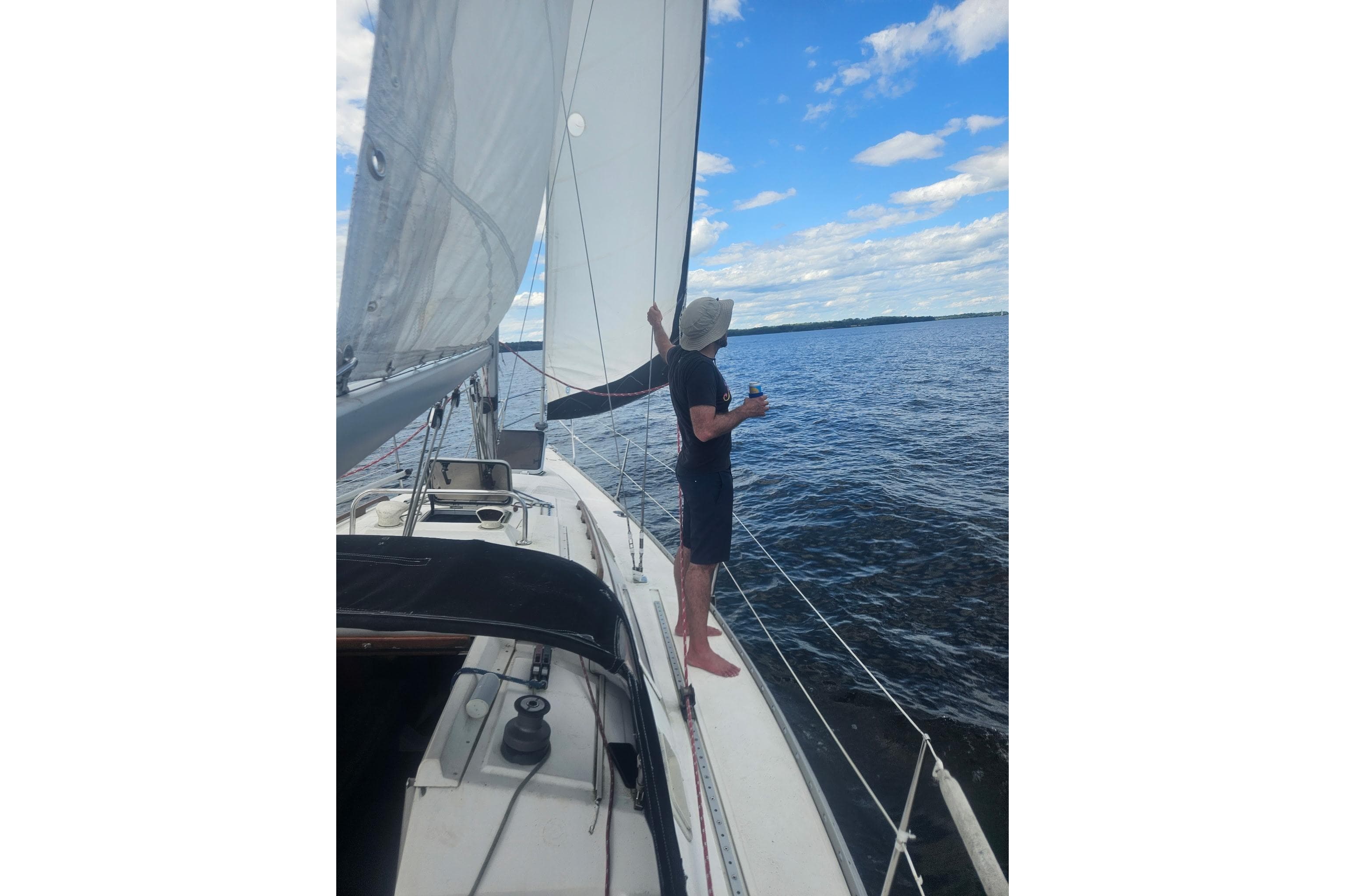 Man sailing on 1985 Hunter 31 yacht, enjoying a sunny day on the water.