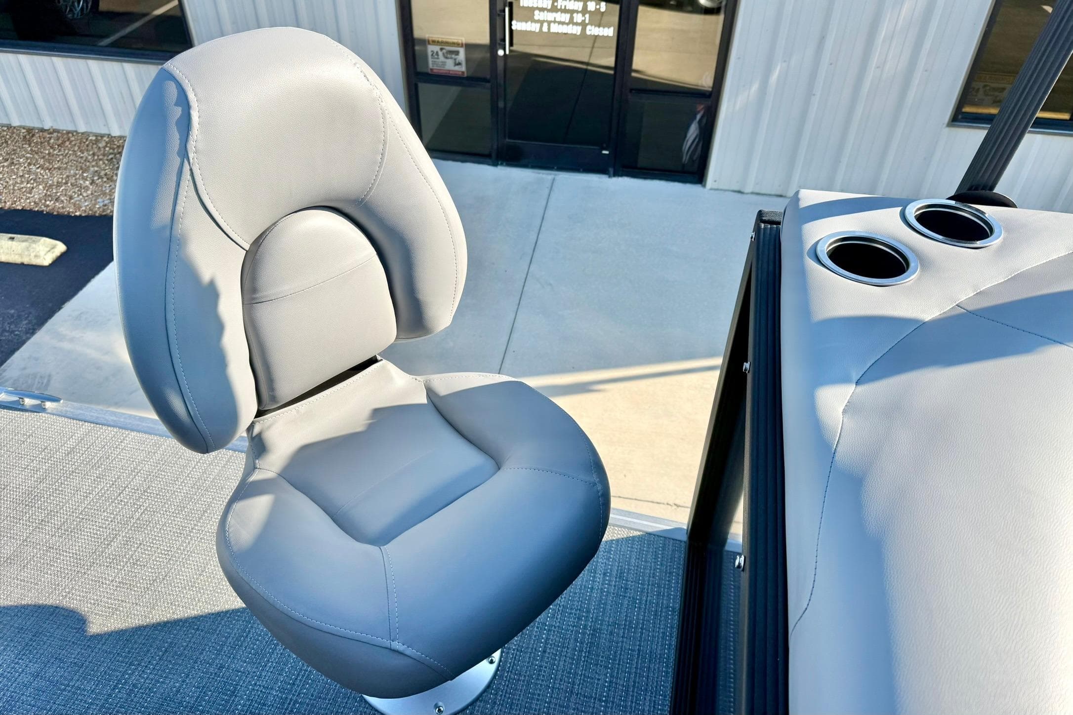 2026 Crest Conquest 210 Fish boat seat with cup holders, outdoor setting.