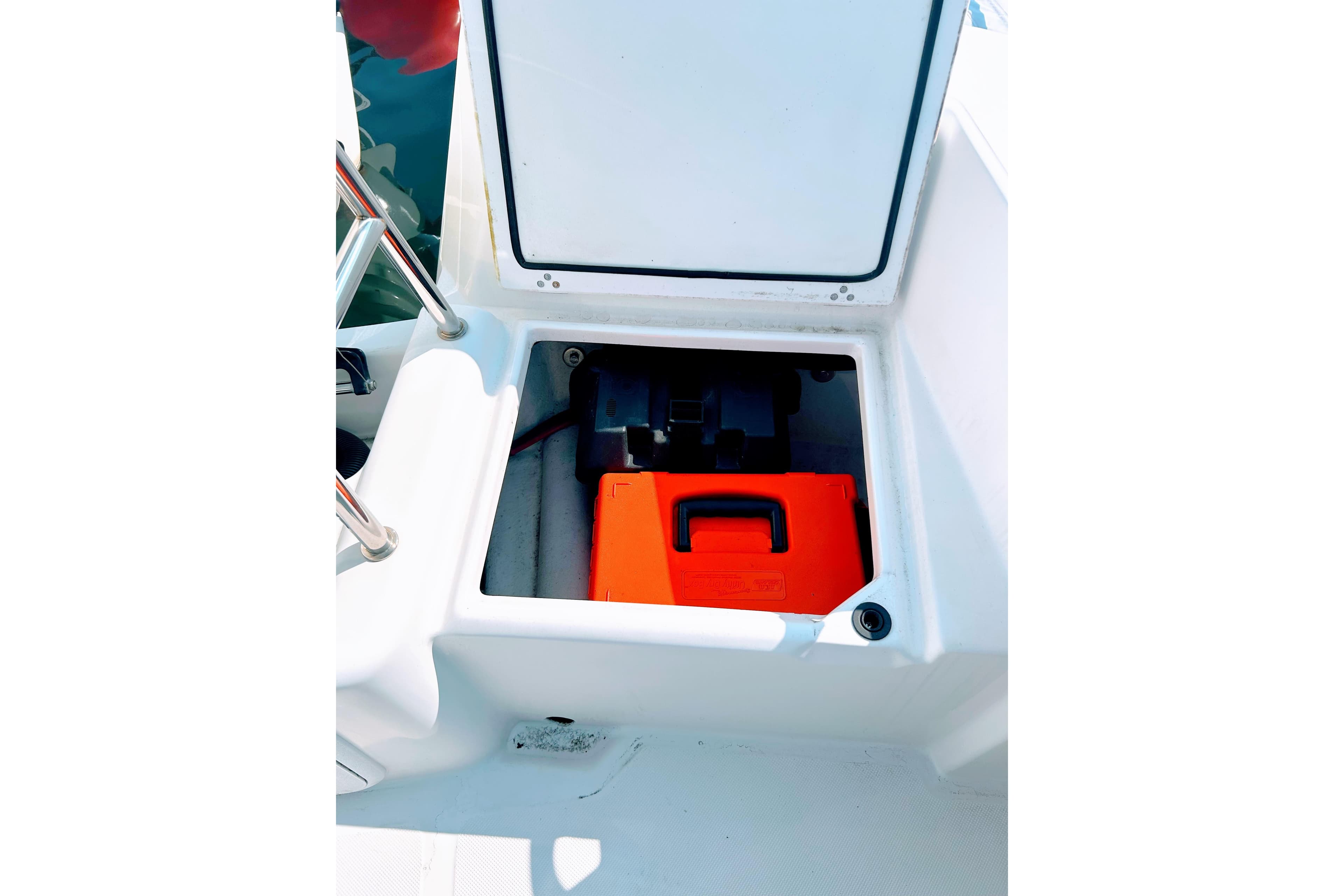 Open storage compartment on 2020 Maritime 23 Challenger boat with red container inside.