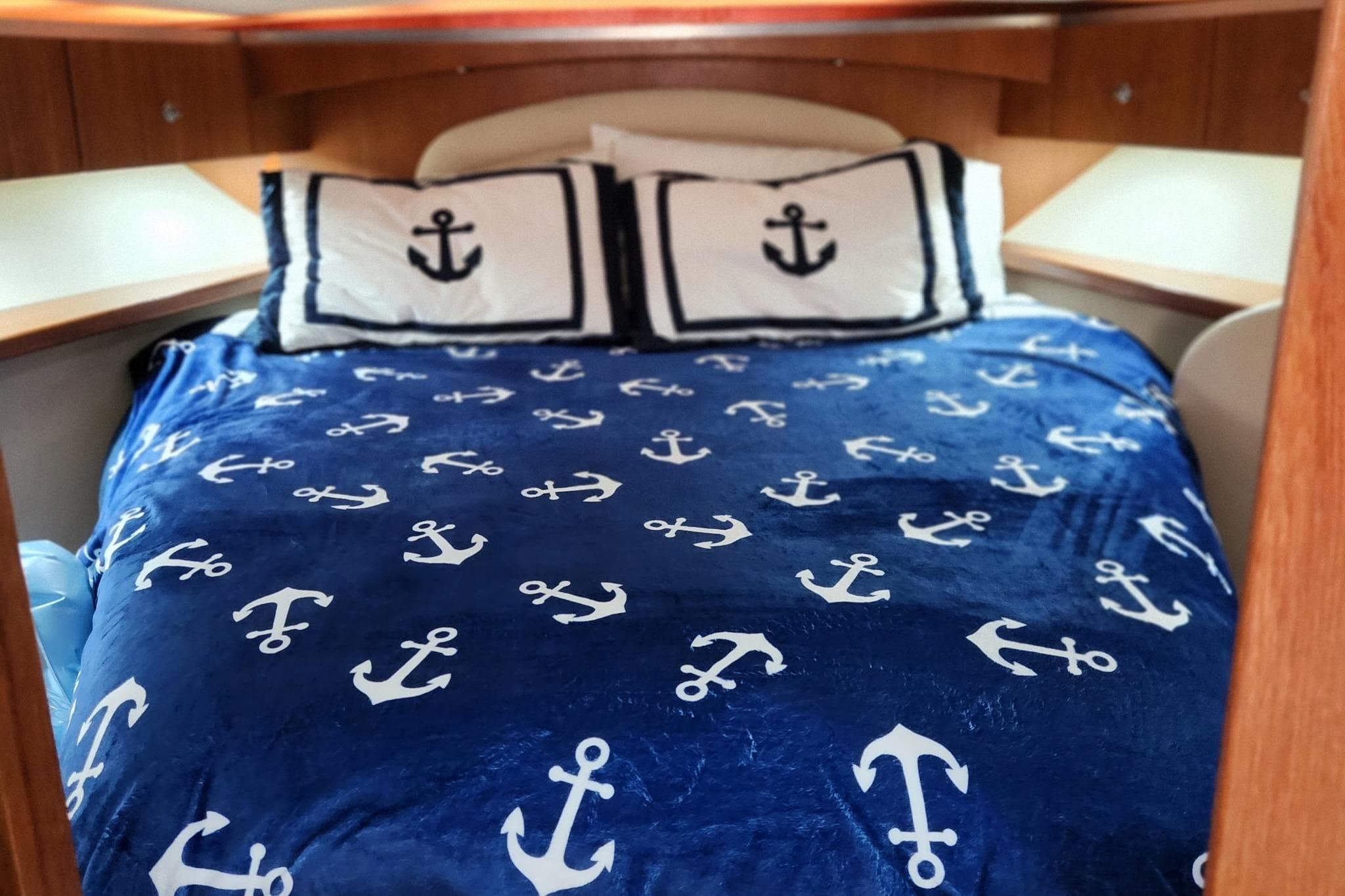 Nautical-themed bed in 2007 Tiara Yachts 3600 Open cabin, featuring anchor-patterned bedding.
