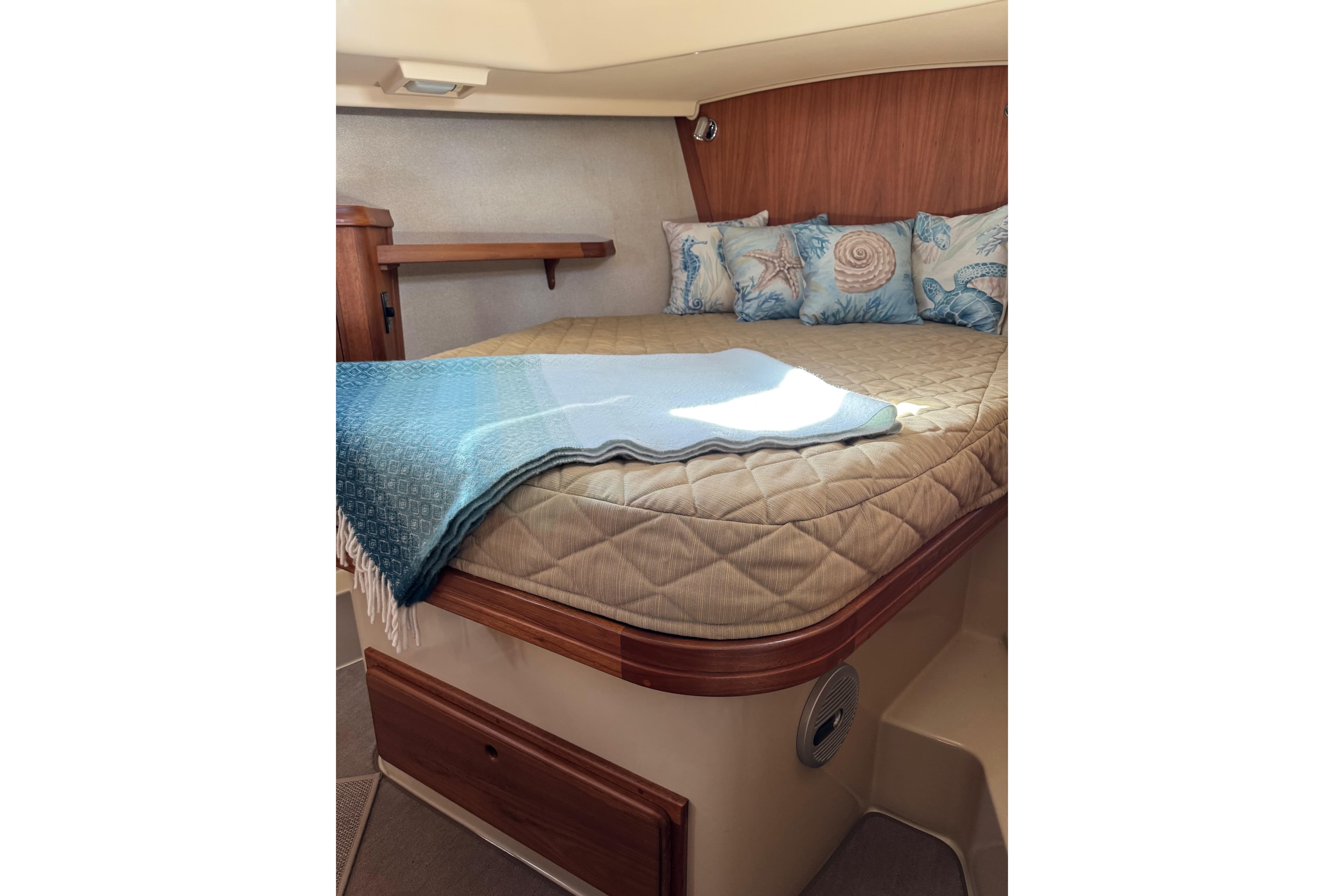 Cozy cabin interior of 2008 Island Packet SP Cruiser with nautical-themed pillows.