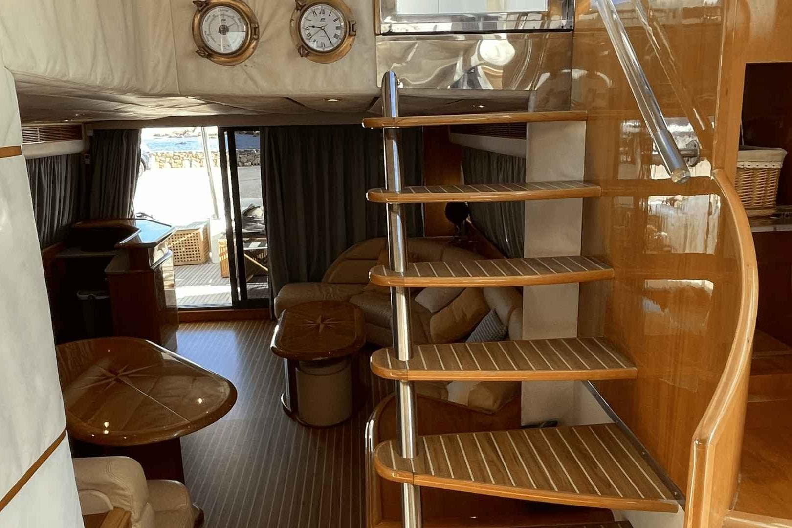 Luxurious interior of a 1998 Guy Couach 2100 yacht with wooden spiral staircase.