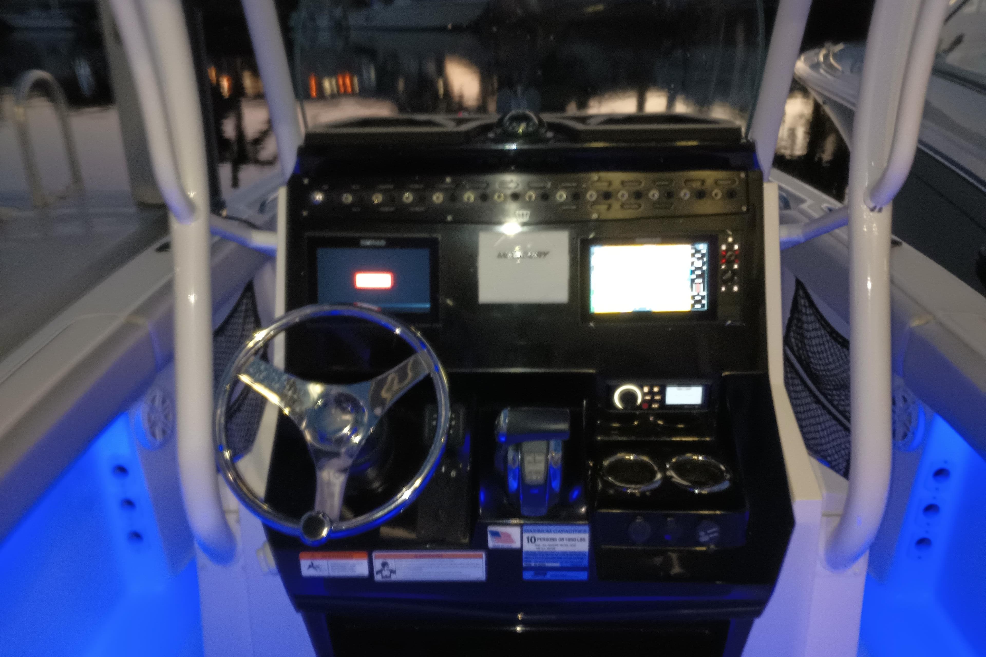 2019 Wellcraft 242 Scarab Offshore boat dashboard with illuminated controls and steering wheel.