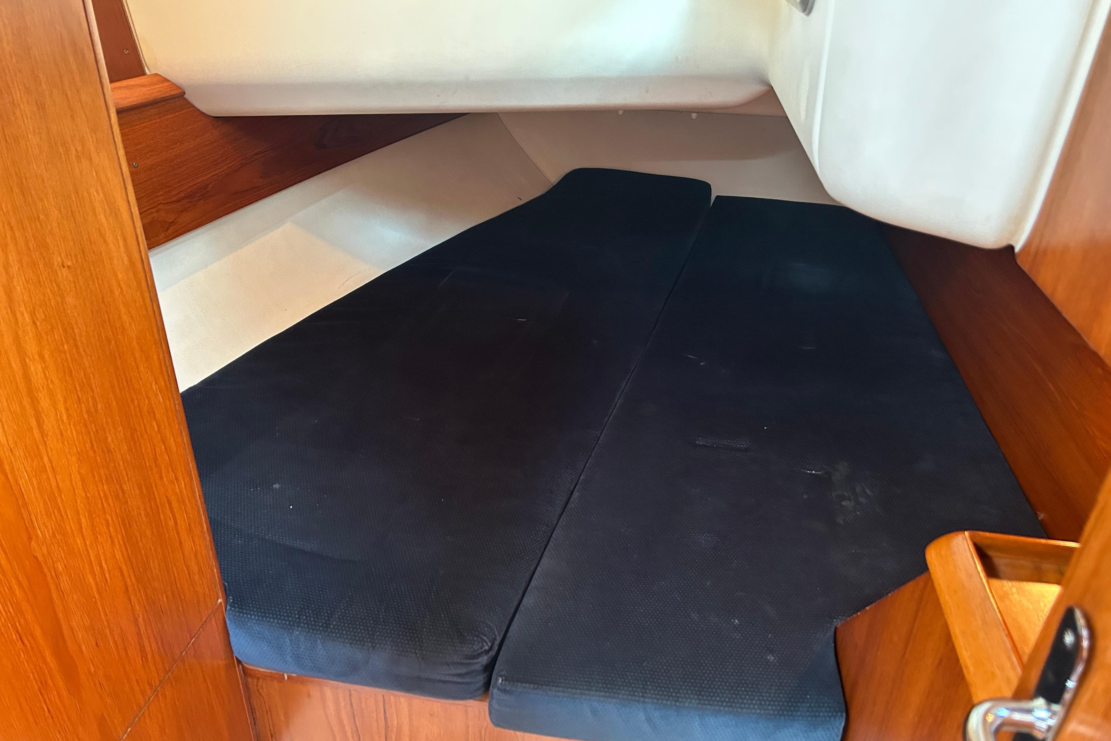 Interior cabin of 2000 Jeanneau Sun Odyssey 40 sailboat with black cushions.