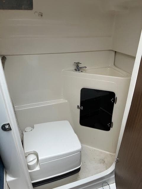 2002 MacGregor 26X boat bathroom with compact toilet and sink.
