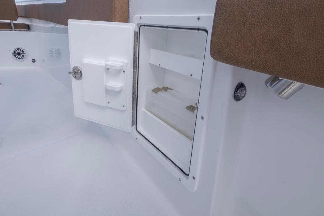 2026 Sea Hunt Ultra 275 SE boat storage compartment with open door and brown seating.