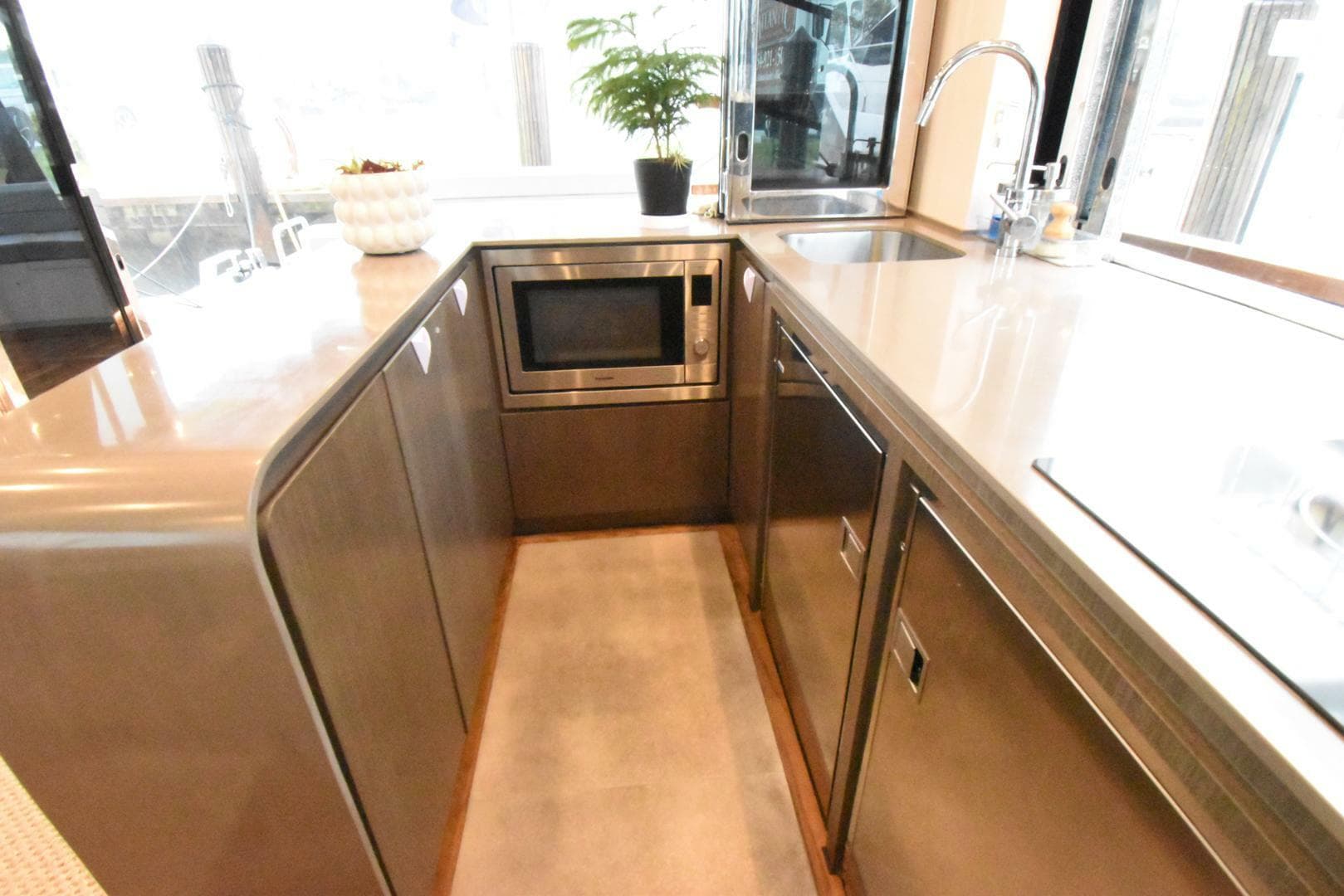 Modern kitchen area in 2024 OKEAN 52 yacht with sleek cabinetry and appliances.