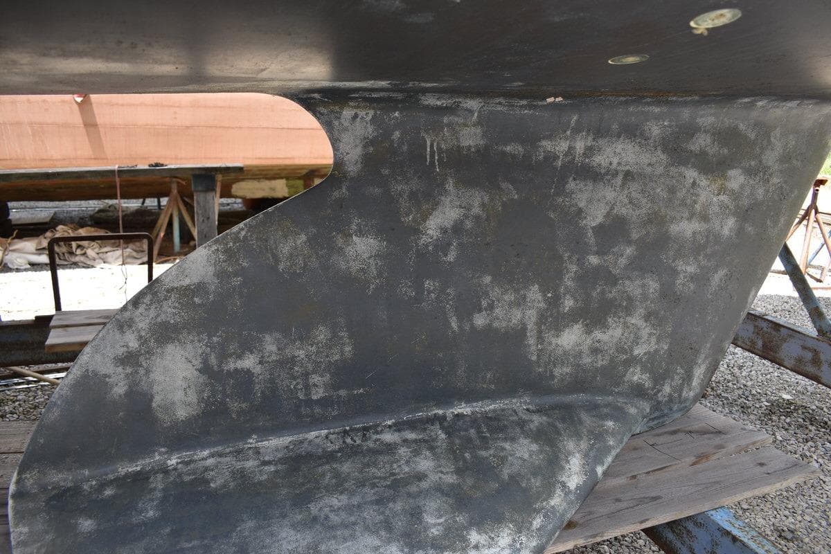 Close-up of a 2001 Catalina 310 sailboat keel in a boatyard setting.