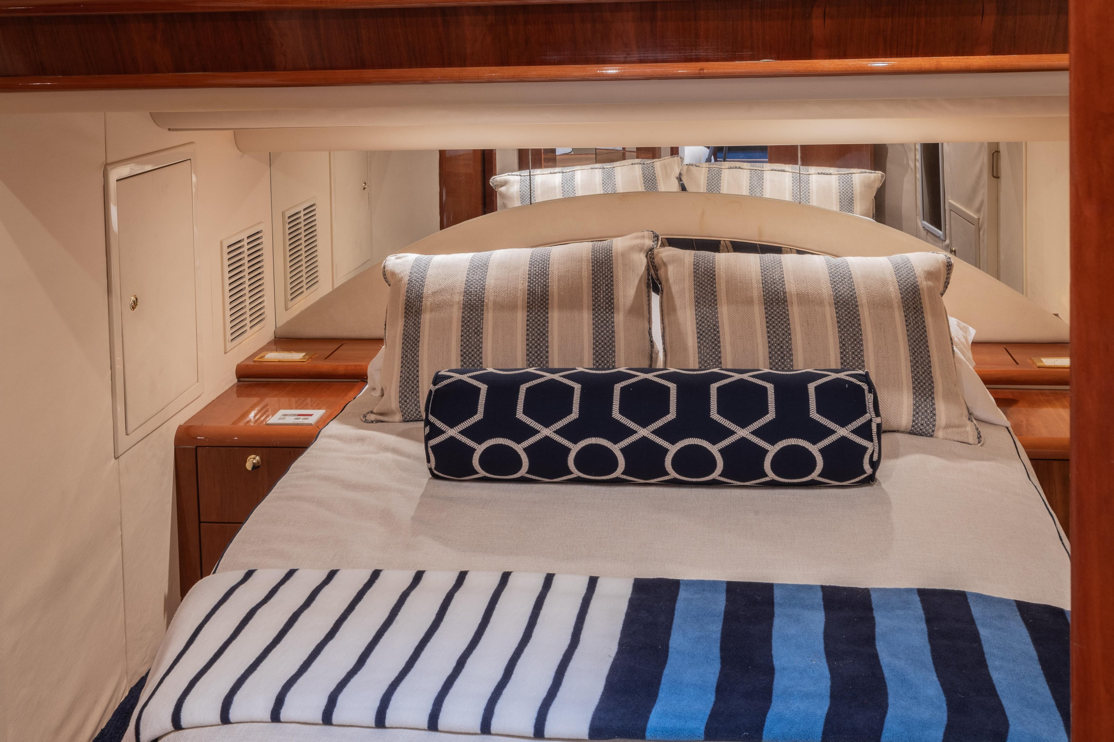 Luxurious cabin interior of 2000 Neptunus 54 Express yacht with striped bedding.