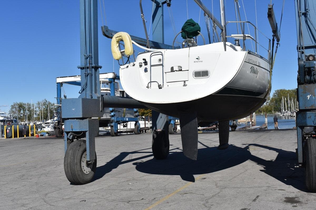 1996 Beneteau Oceanis 321 sailboat lifted by crane at marina dock.