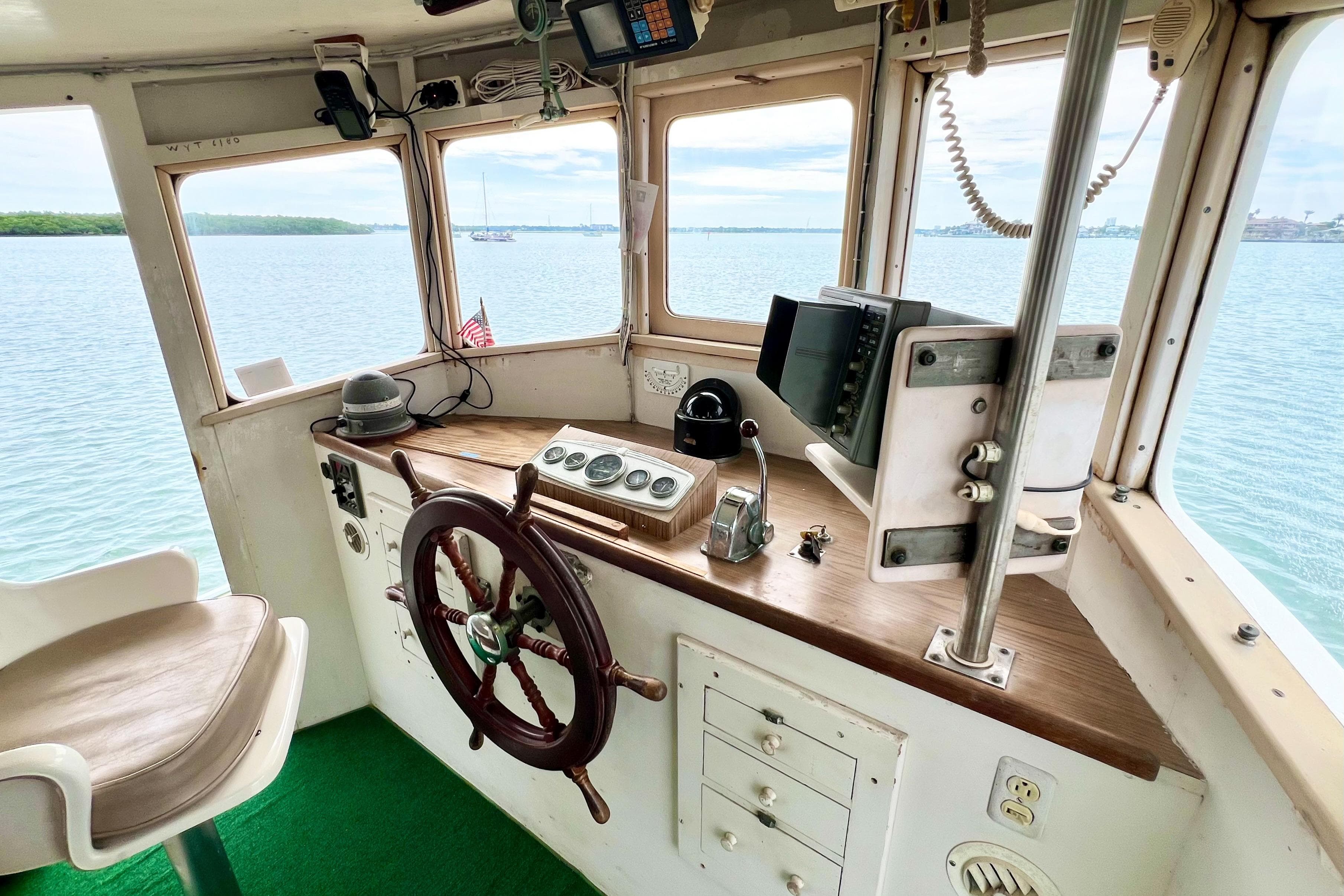 Interior of a 1972 Mills Boat Works Tug Boat with steering wheel and navigation equipment.