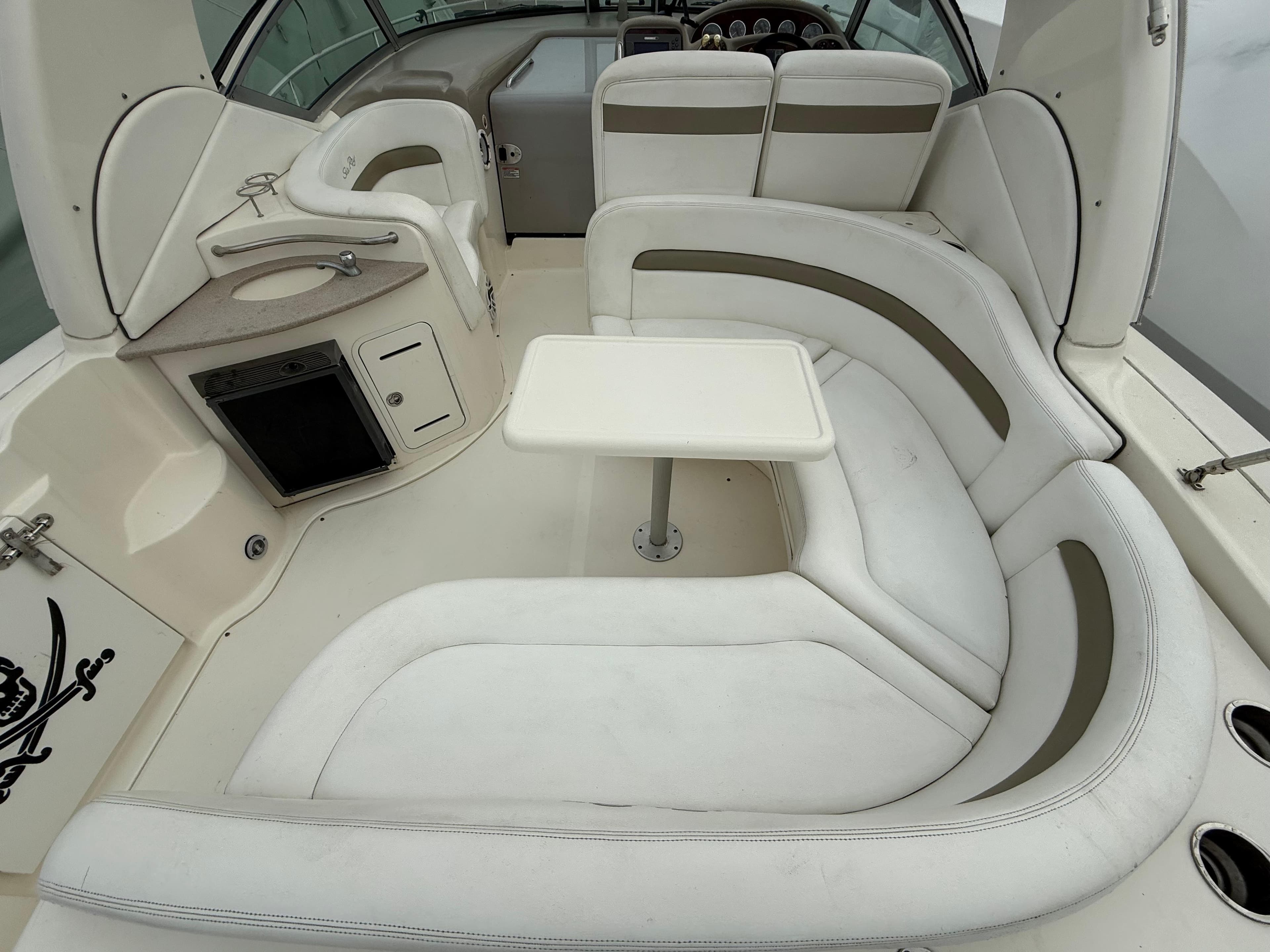 2006 Sea Ray 320 Sundancer interior with white seating and compact table.