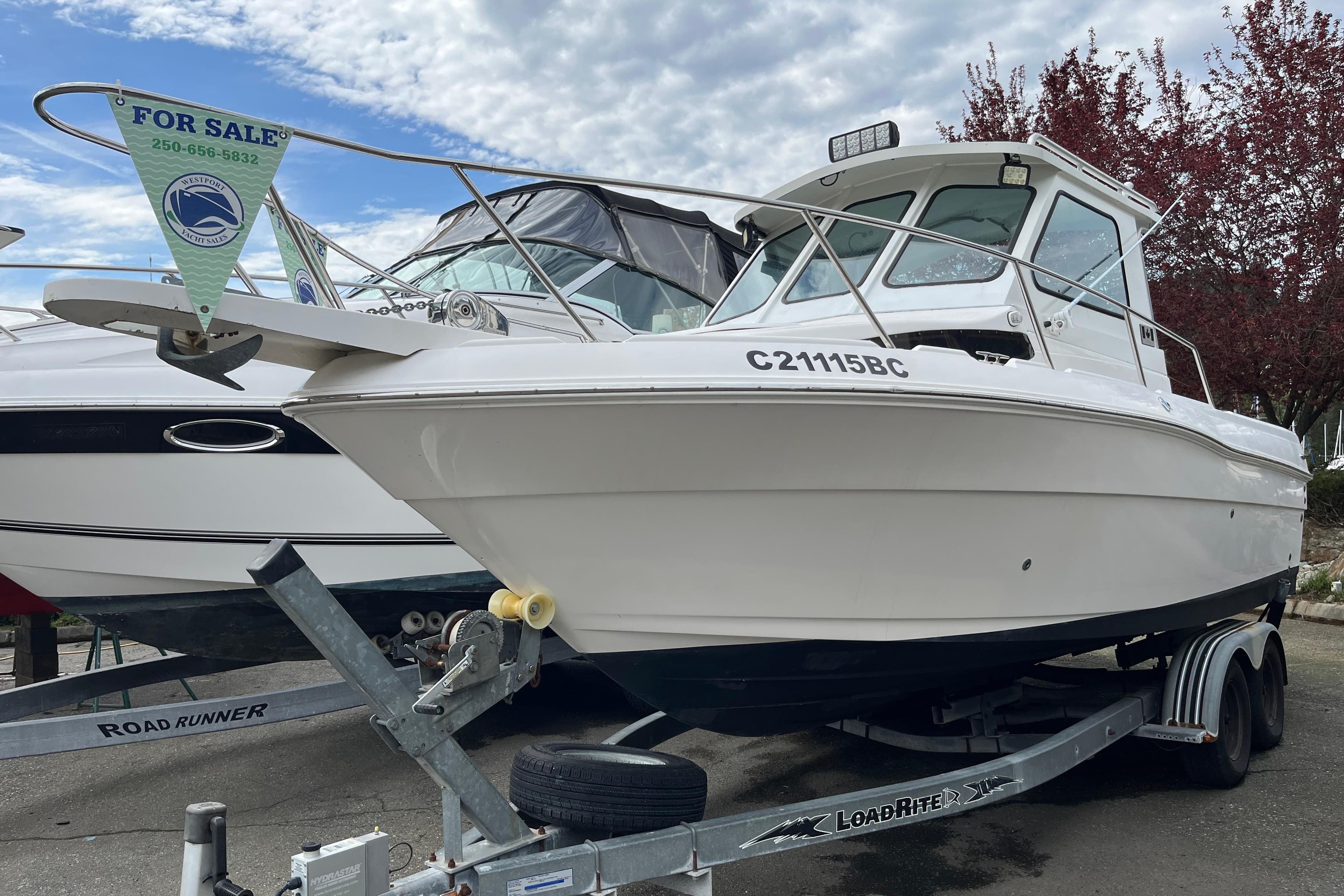 2003 Campion Explorer 682 Sport Cabin boat for sale on trailer, under cloudy sky.