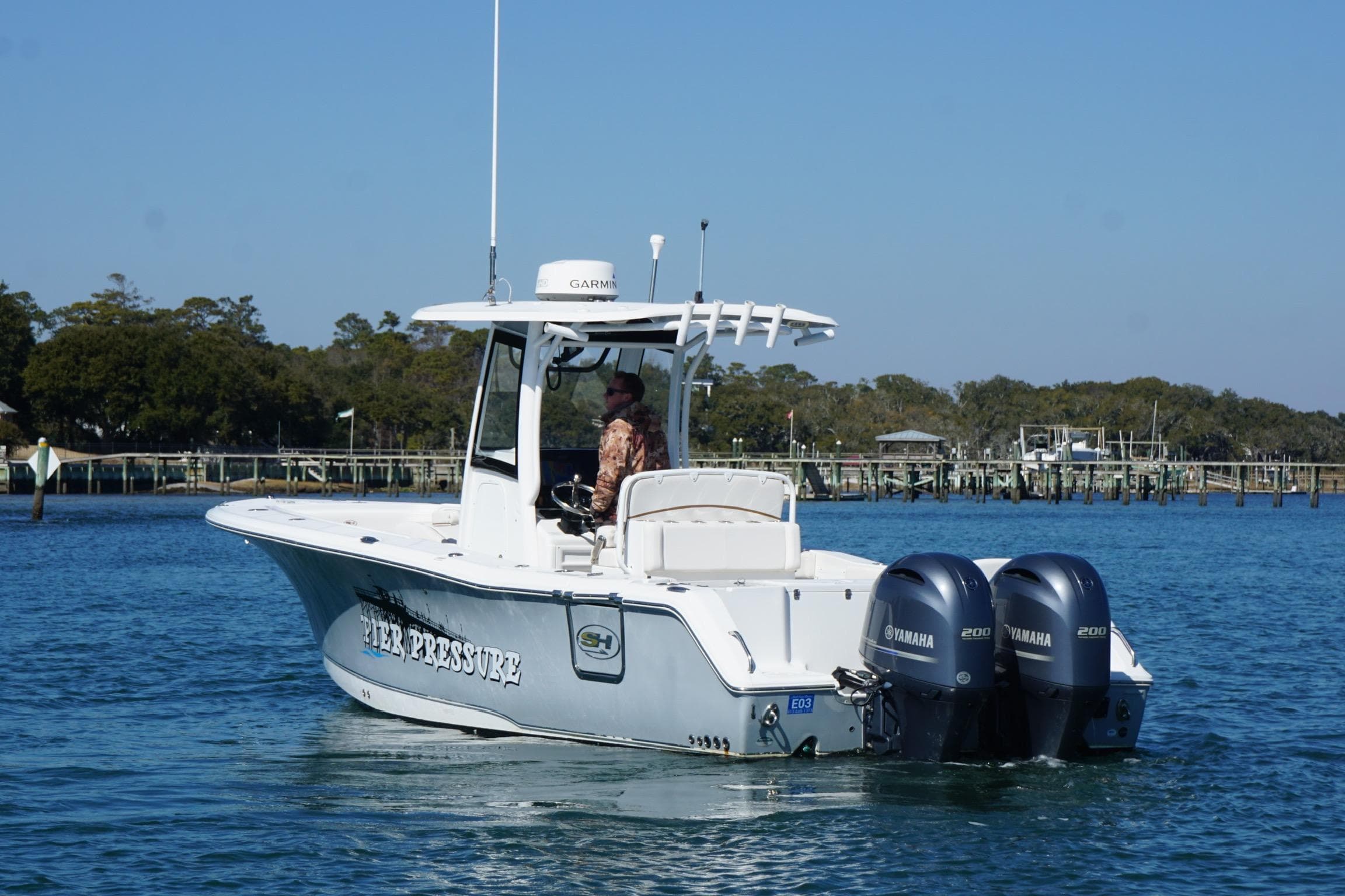 2020 Sea Hunt Gamefish 27 boat with dual Yamaha engines on a calm waterway.