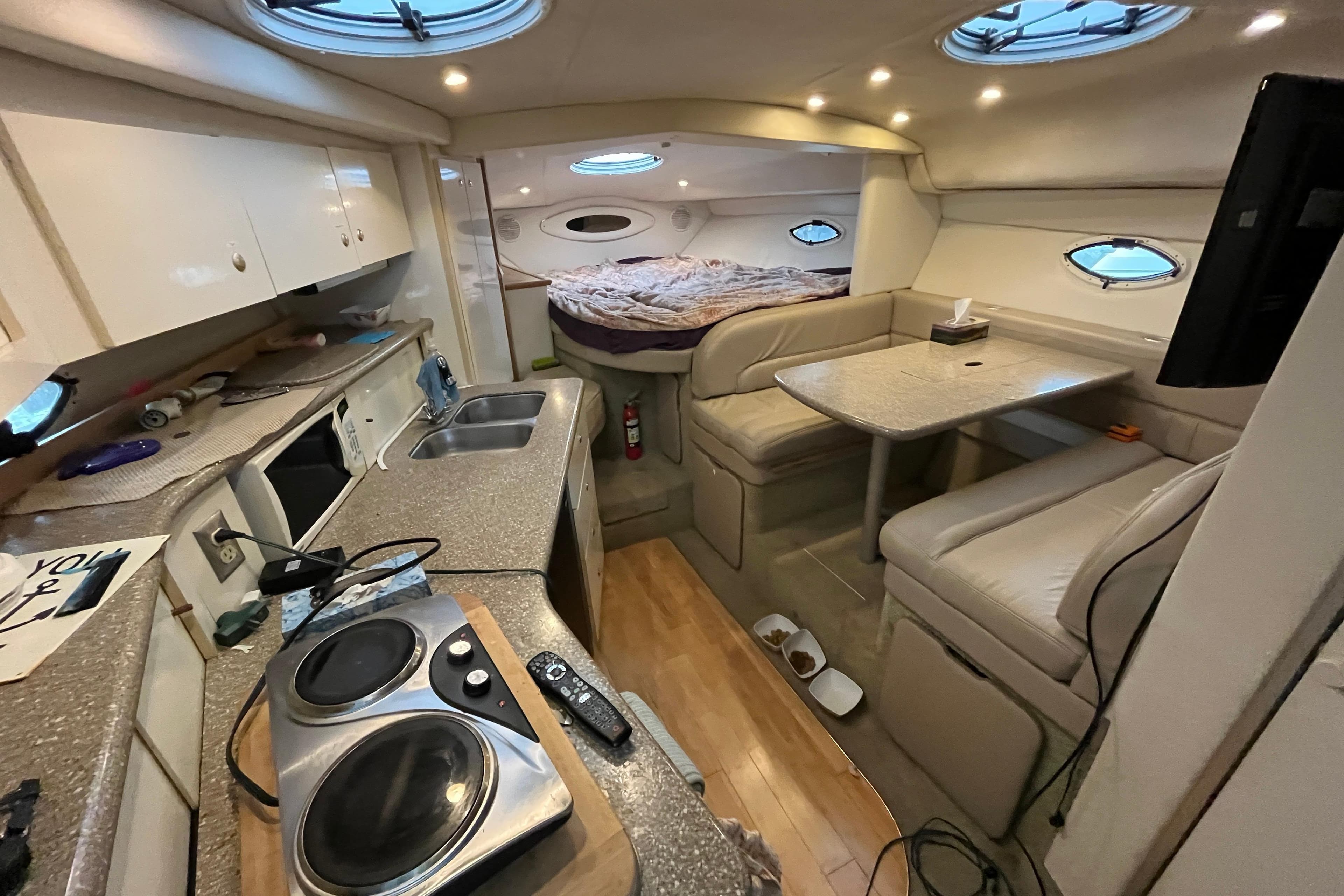 Interior of 2000 Maxum 3300 SCR yacht with kitchen, dining area, and bed.