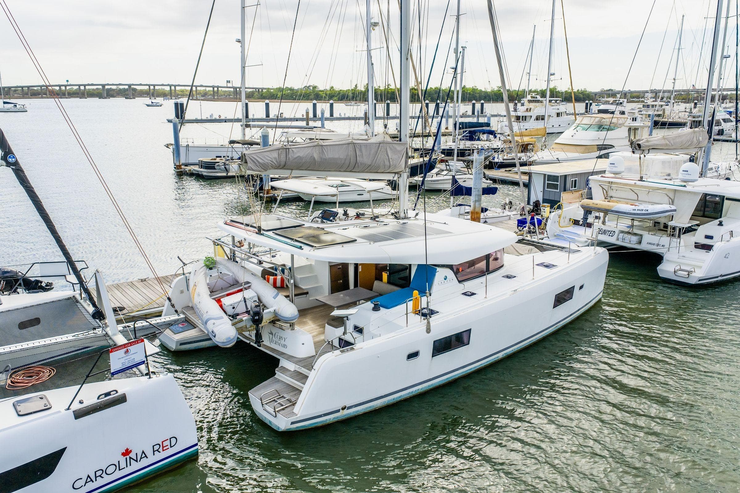 2017 Lagoon 42 catamaran docked in a marina, surrounded by other boats.