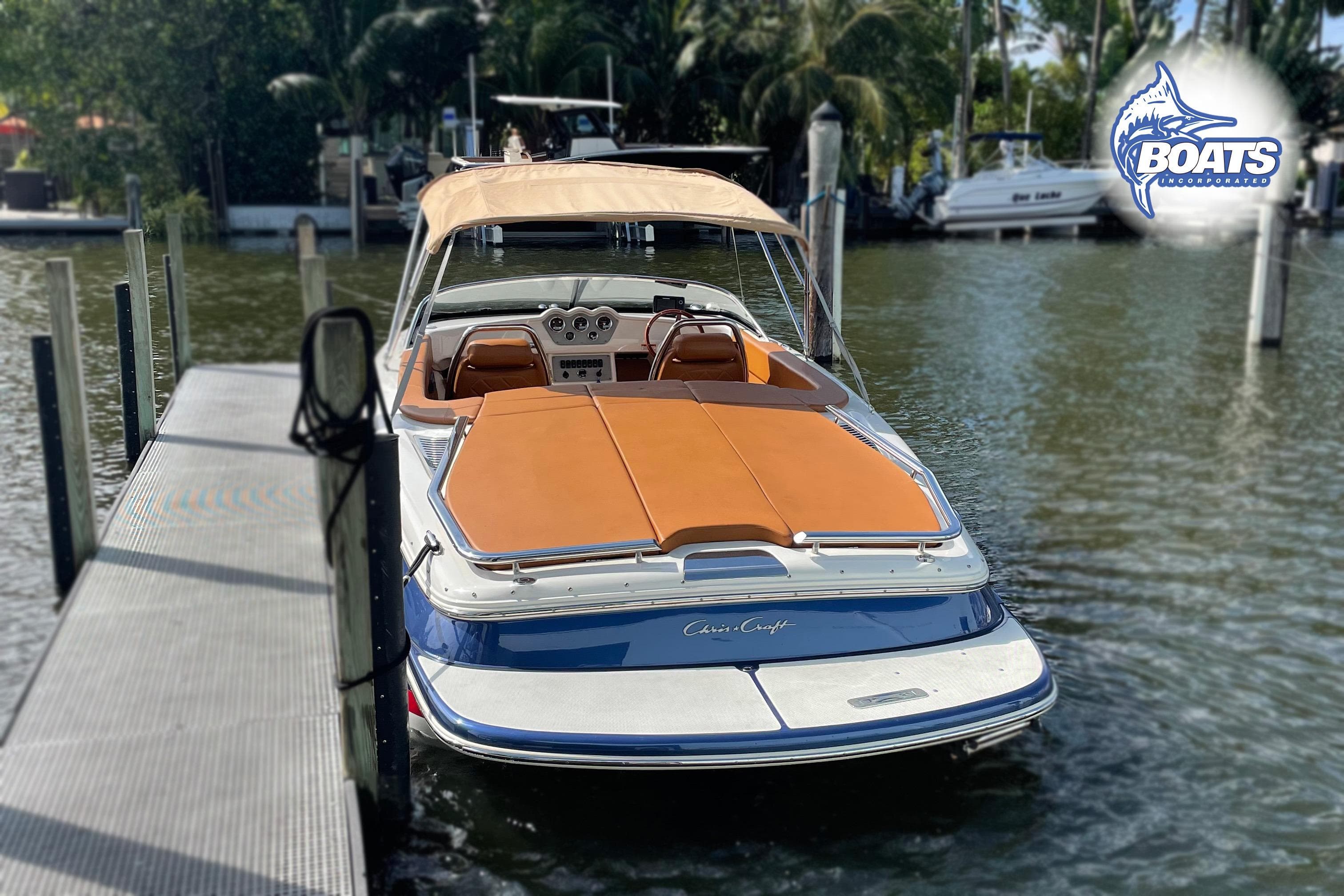 2016 Chris-Craft Capri 21 boat docked, featuring tan upholstery and sleek design.