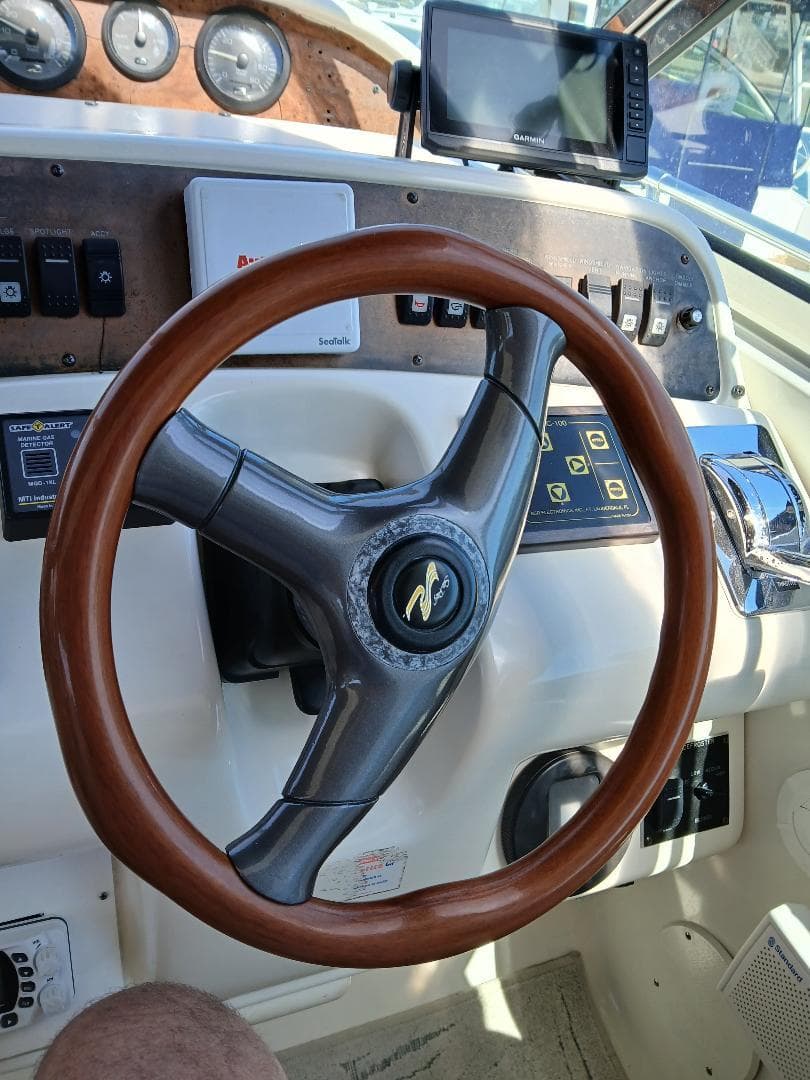 Steering wheel of a 1997 Sea Ray 370 Sundancer boat with control panel.