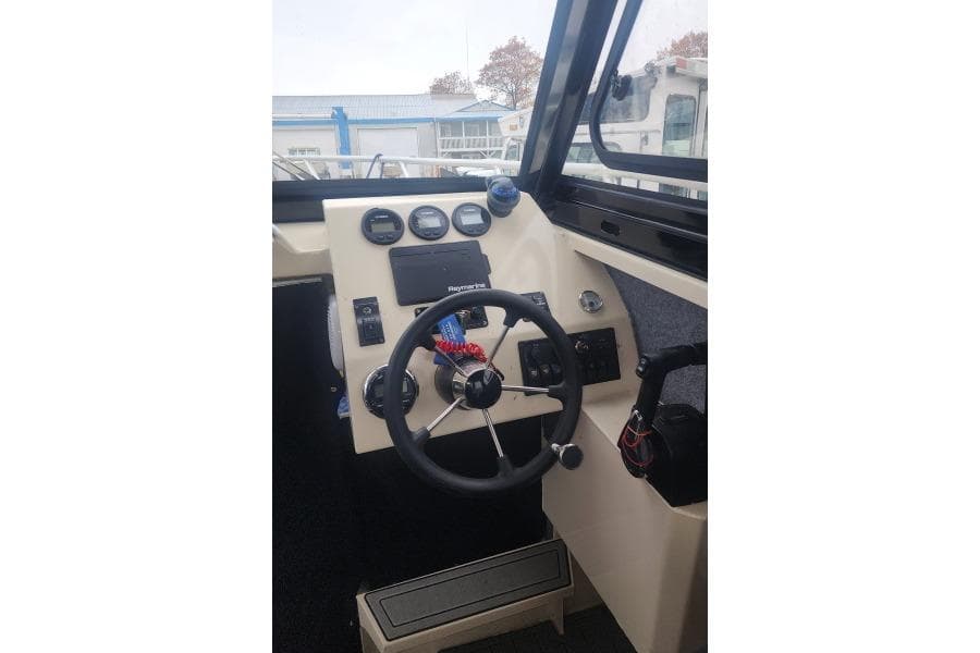 AllSea Profisher 750F 2022 boat cockpit with steering wheel and control panel.