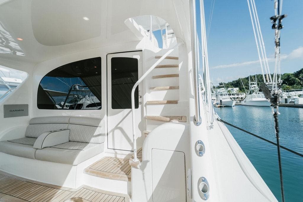 Luxurious 2021 Viking 58 Convertible yacht interior with seating and staircase, docked at marina.