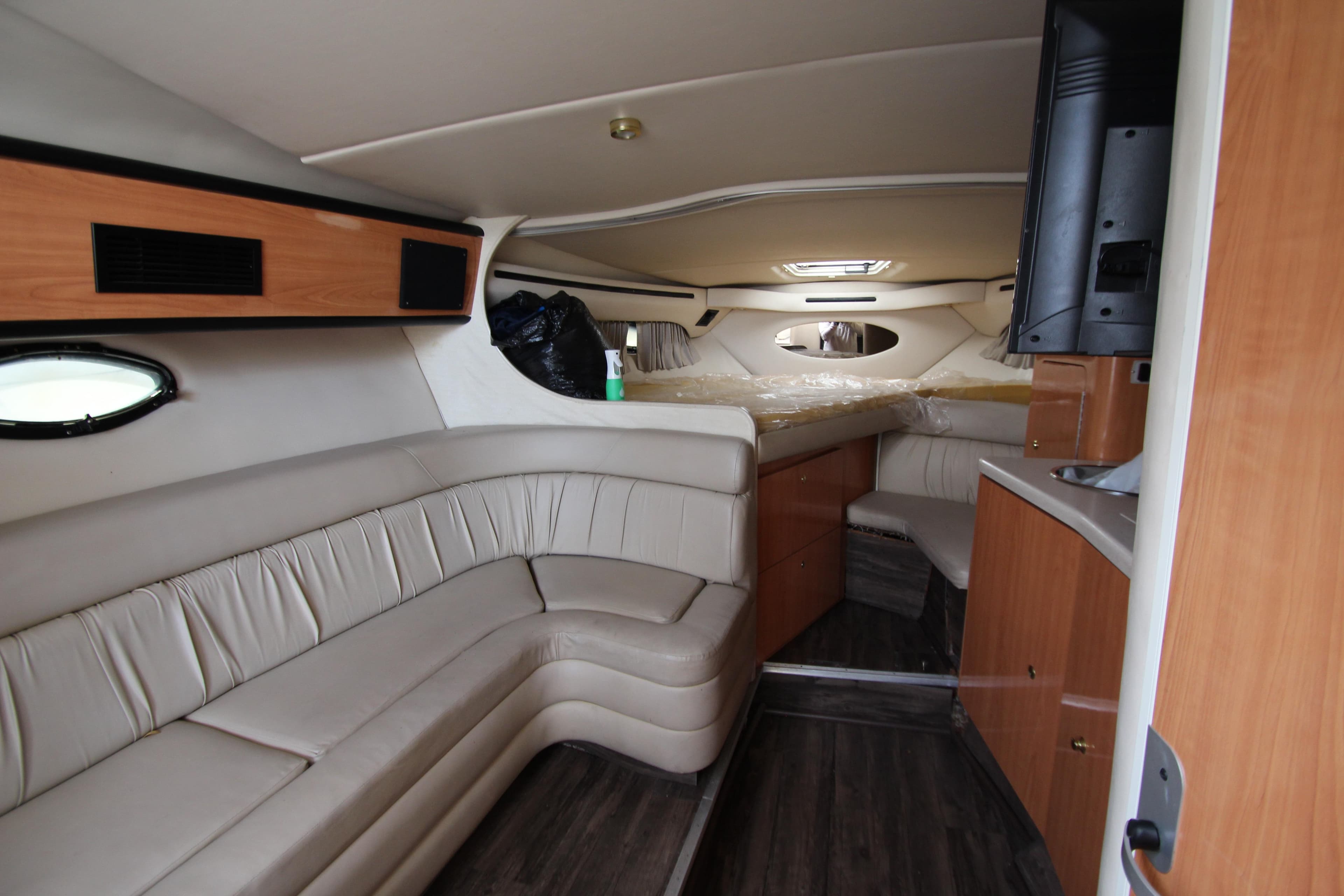 Interior of 1999 Regal Commodore 322 yacht with beige seating and wood accents.