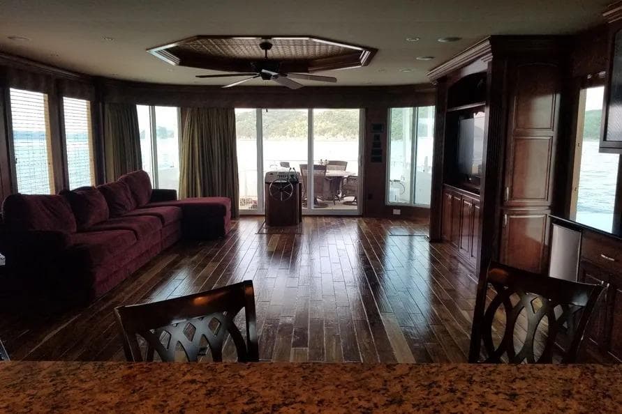 Luxurious 2012 Thoroughbred Houseboat interior with elegant wood flooring and panoramic windows.