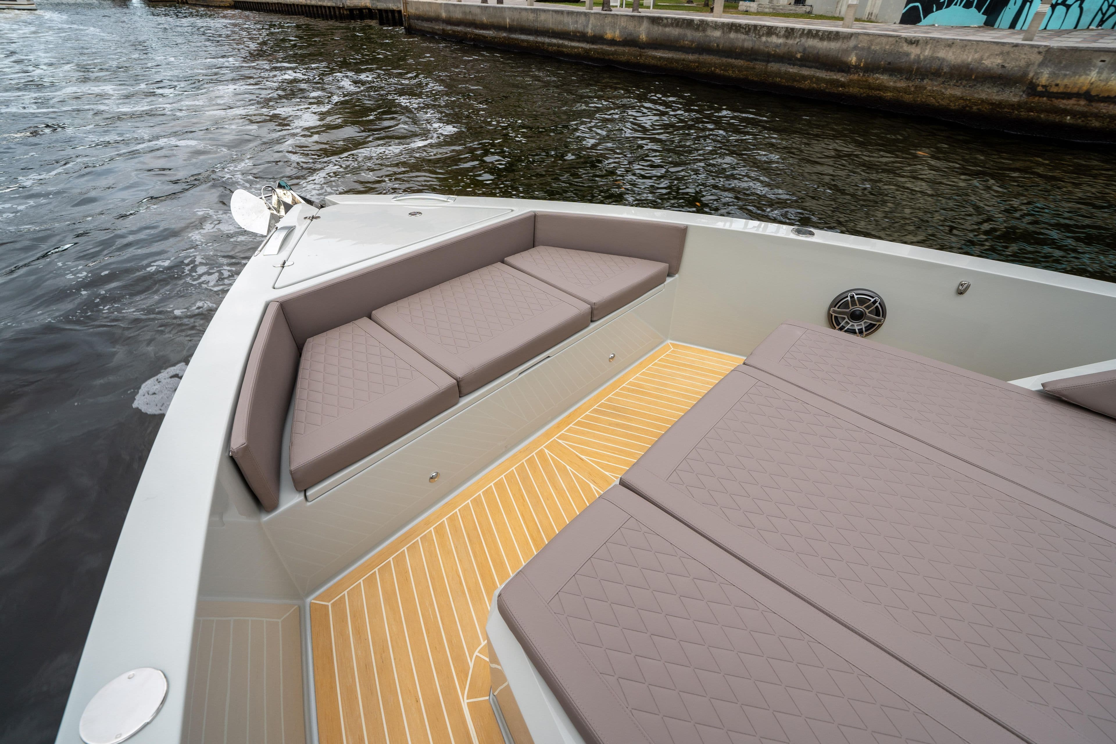 2025 De Antonio Yachts D42 Open with cushioned seating and teak deck on calm water.