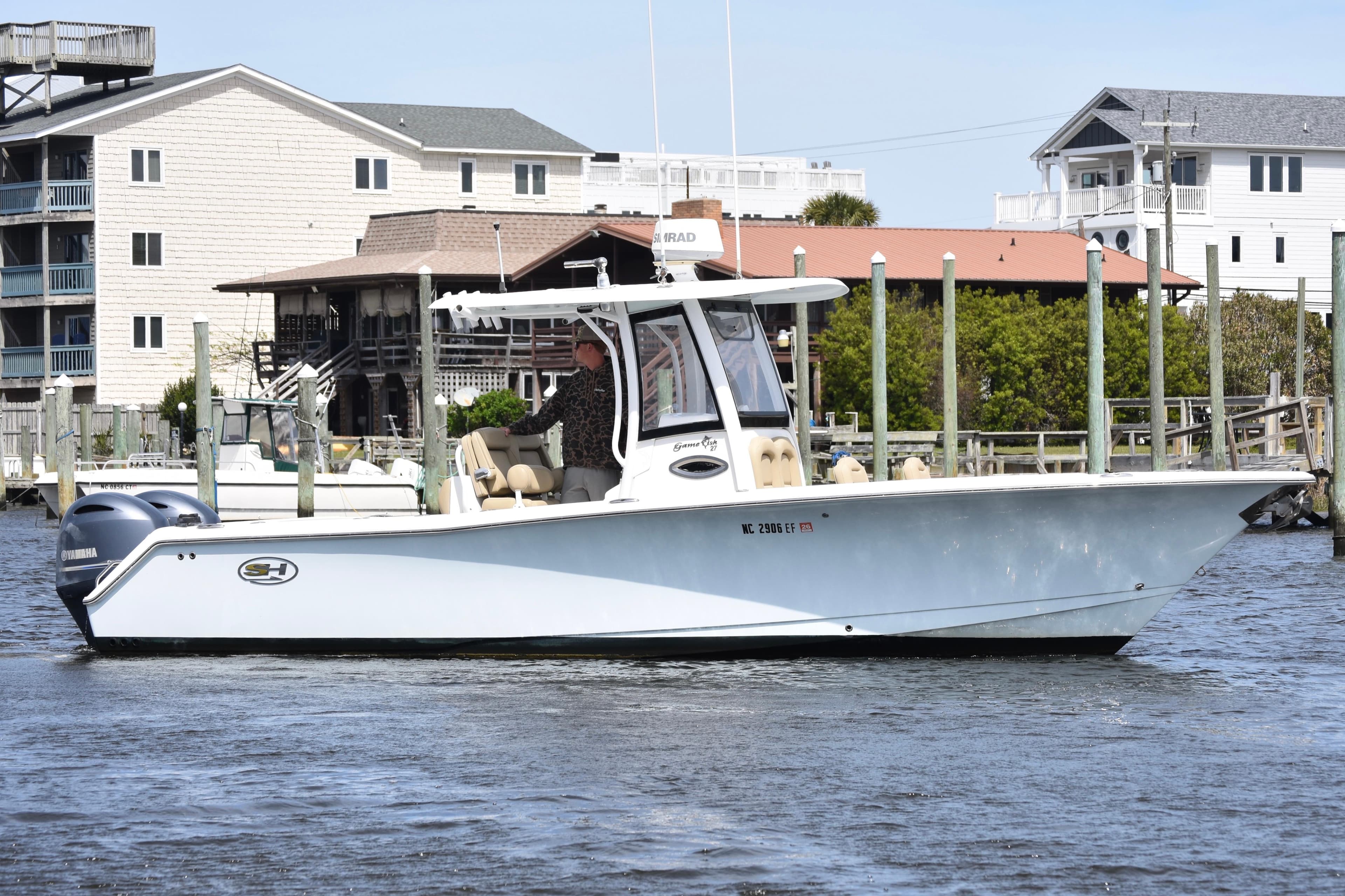 2017 Sea Hunt Gamefish 27 boat with forward seating on a calm waterfront.