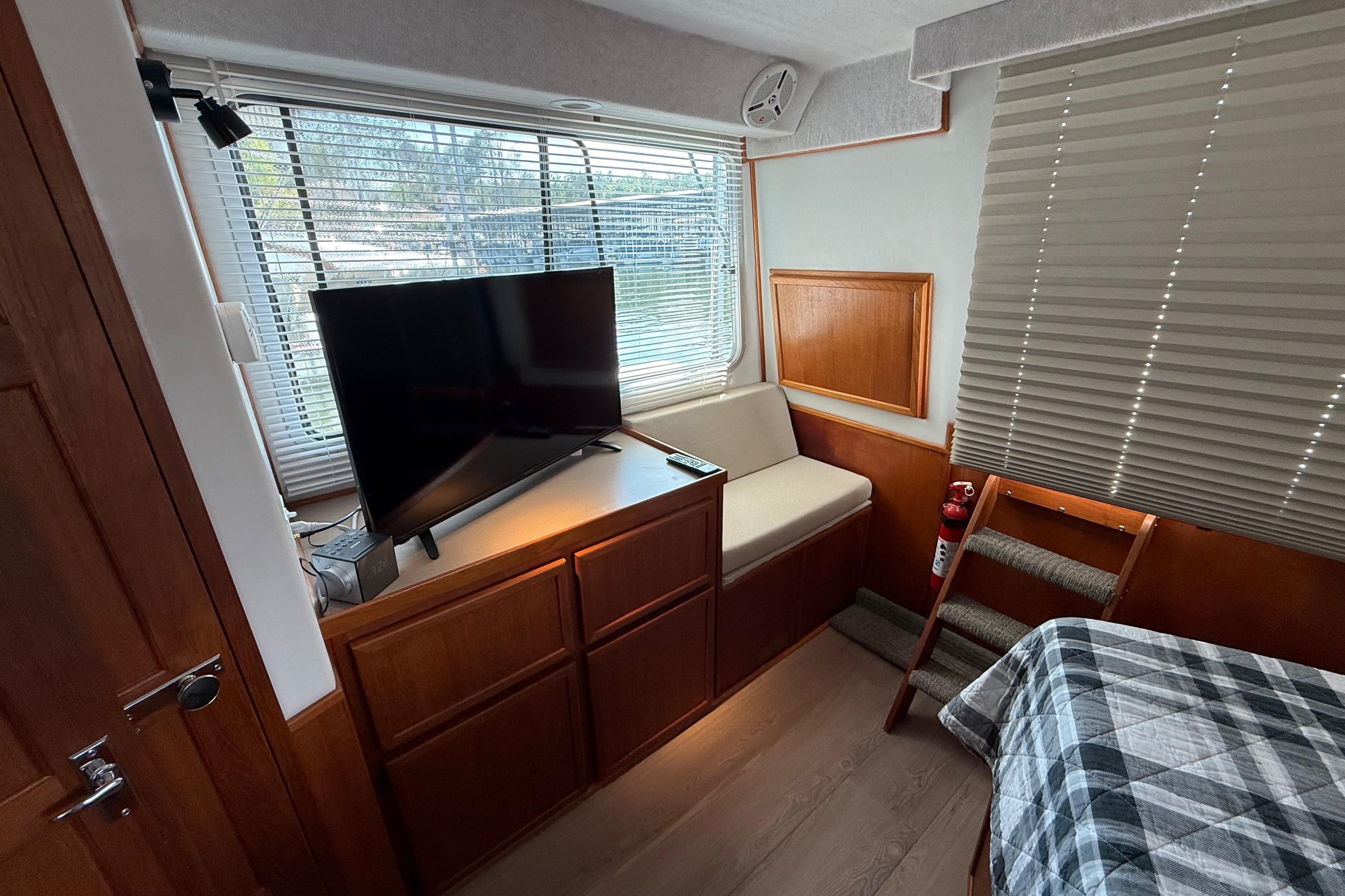 Interior of 1995 Harbor Master 52 Wide Body with TV, seating, and wooden cabinetry.