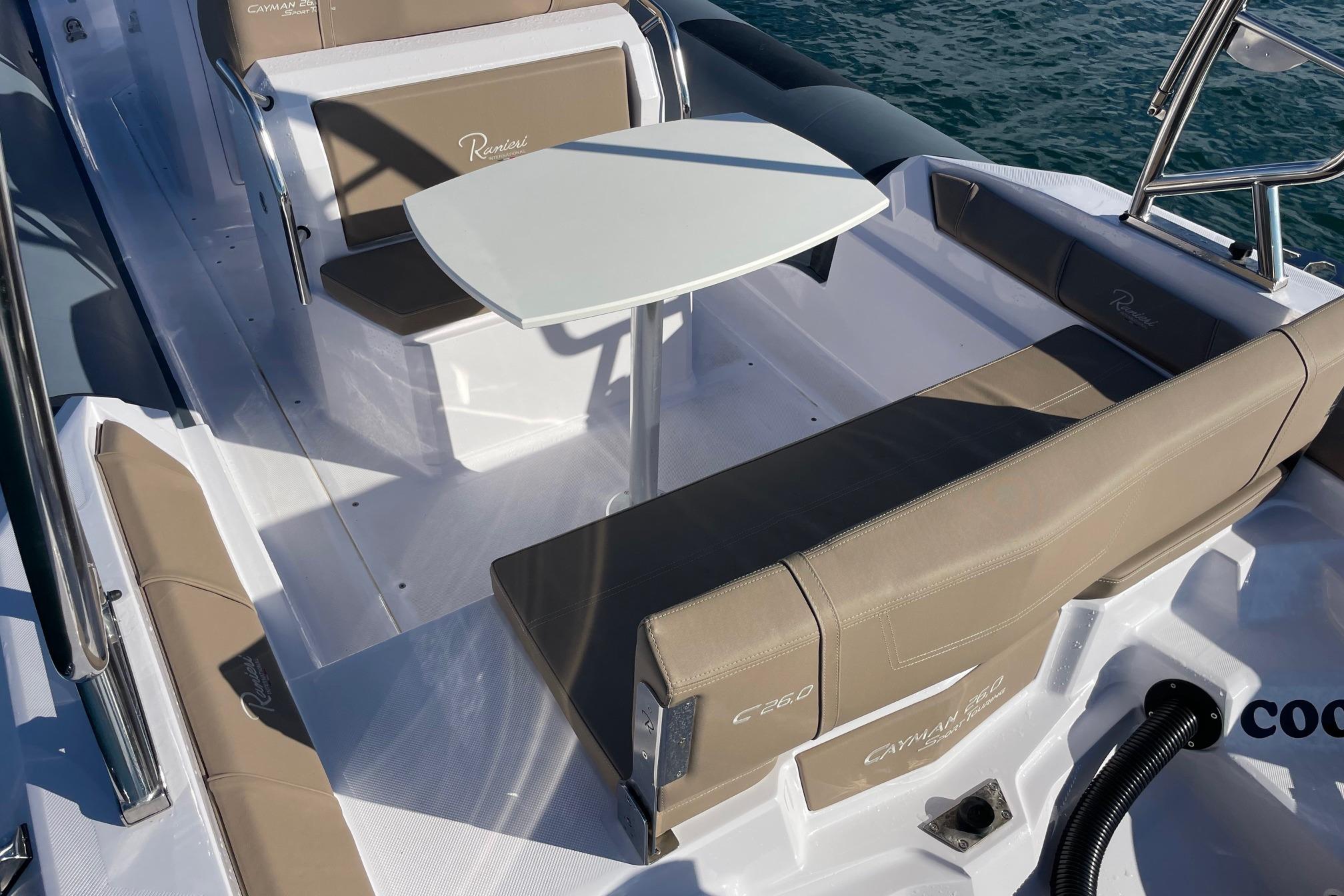 2025 Ranieri CAYMAN 26 SPORT TOURING boat interior with seating and table.