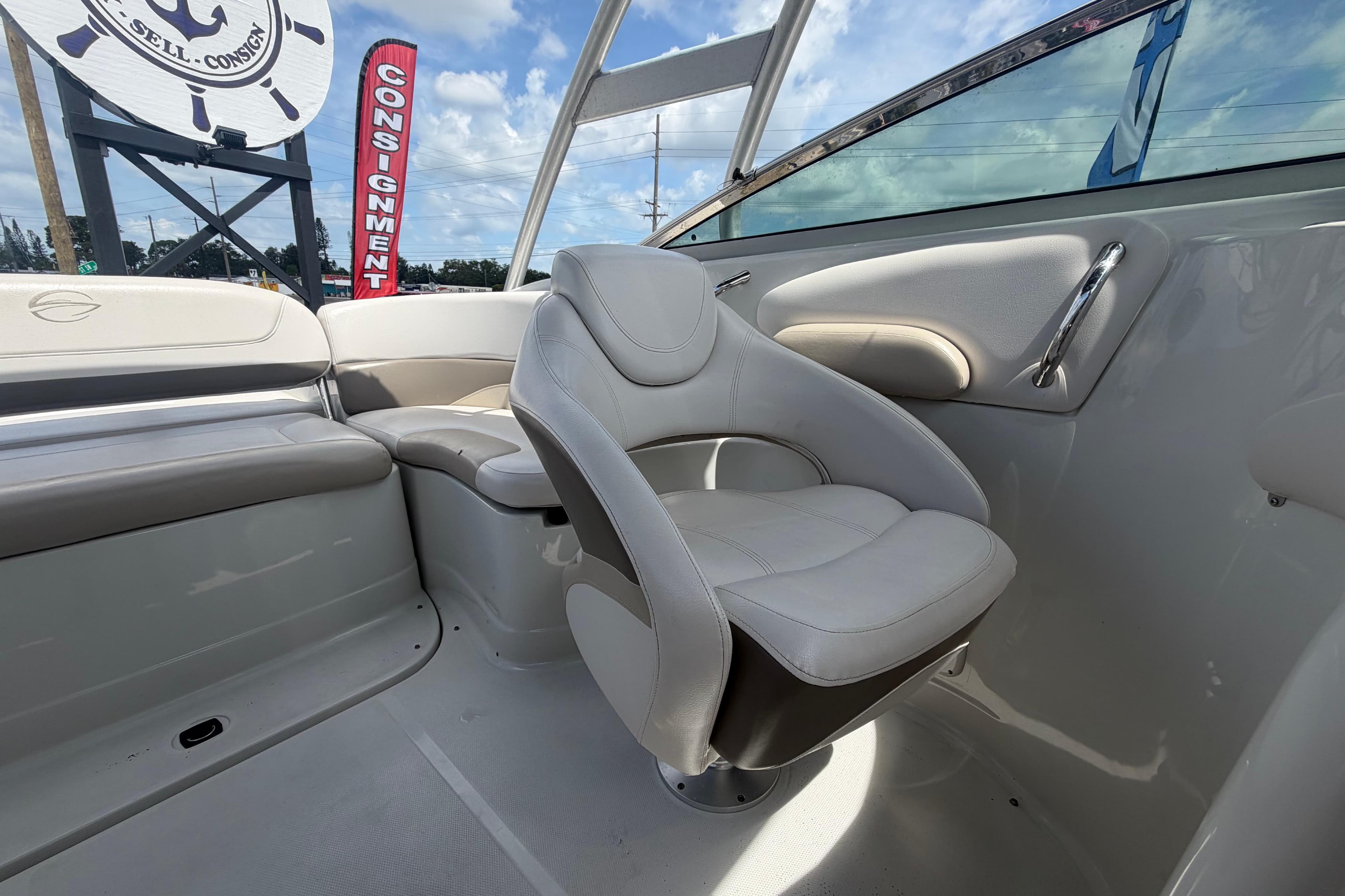 2012 Crownline 236 SC boat interior with plush seating and consignment sign in background.