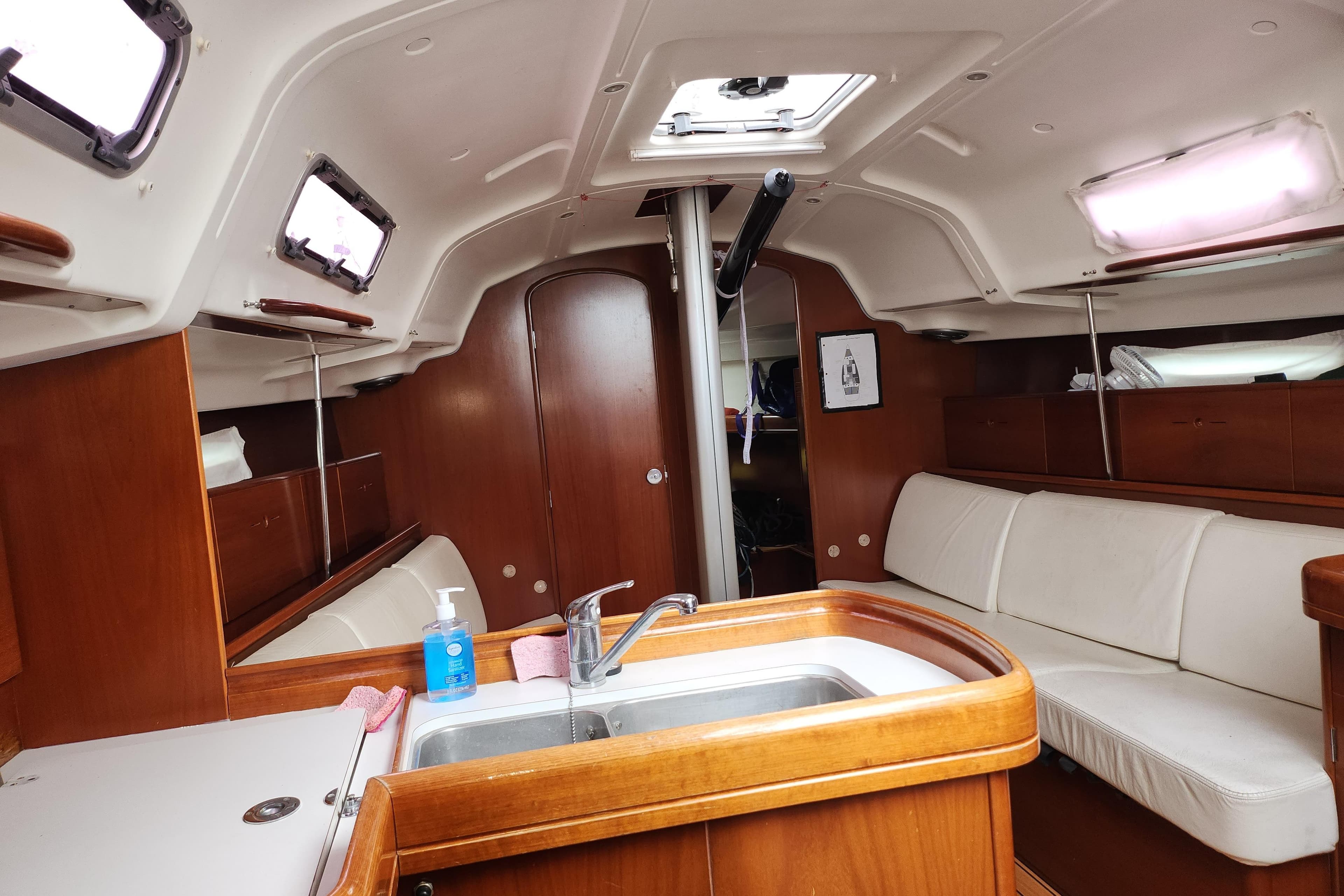 Interior of 2004 Beneteau First 36.7 sailboat with wood finish and white seating.