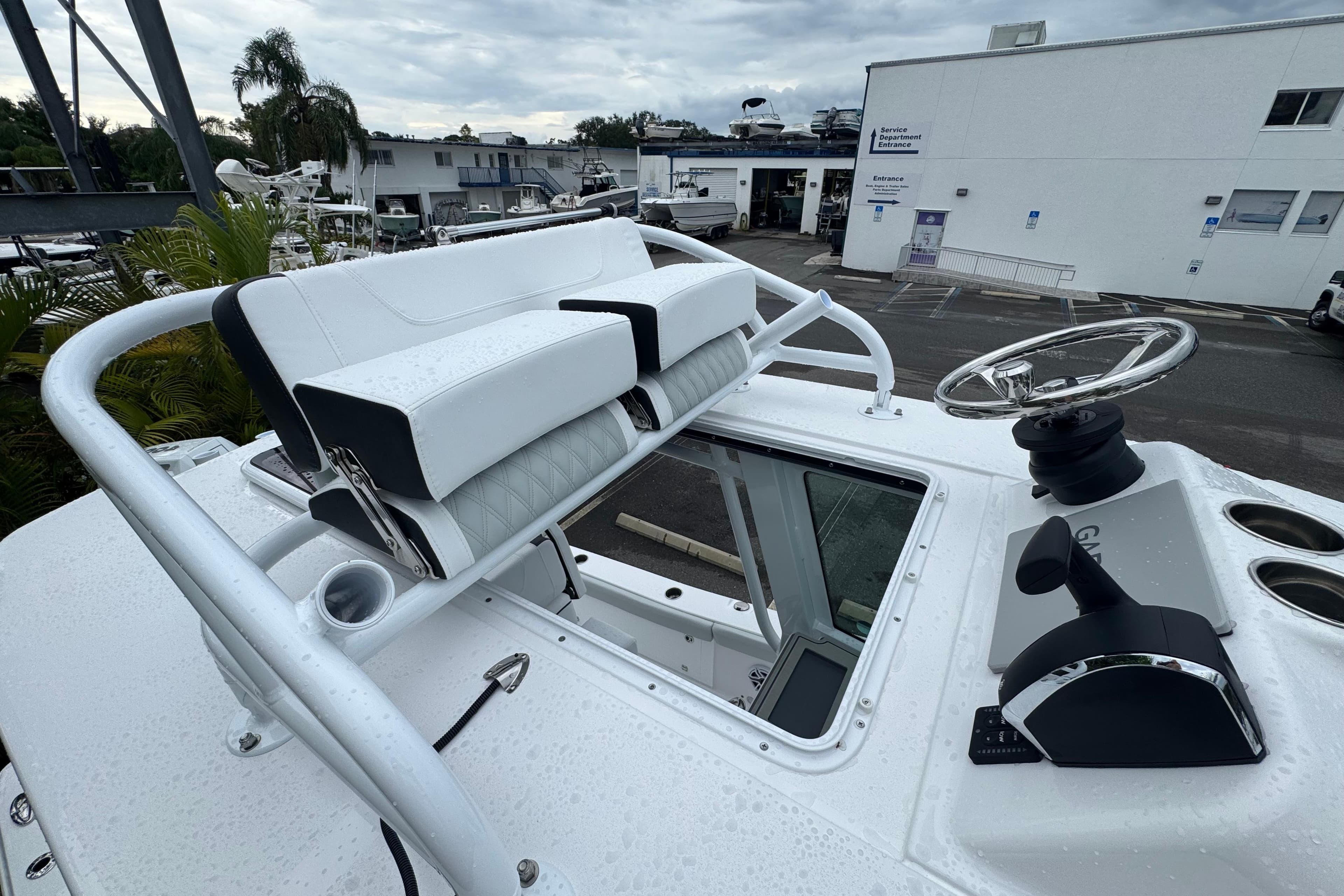 2026 Blackfin 262 HB boat helm with steering wheel and seating, in a marina setting.