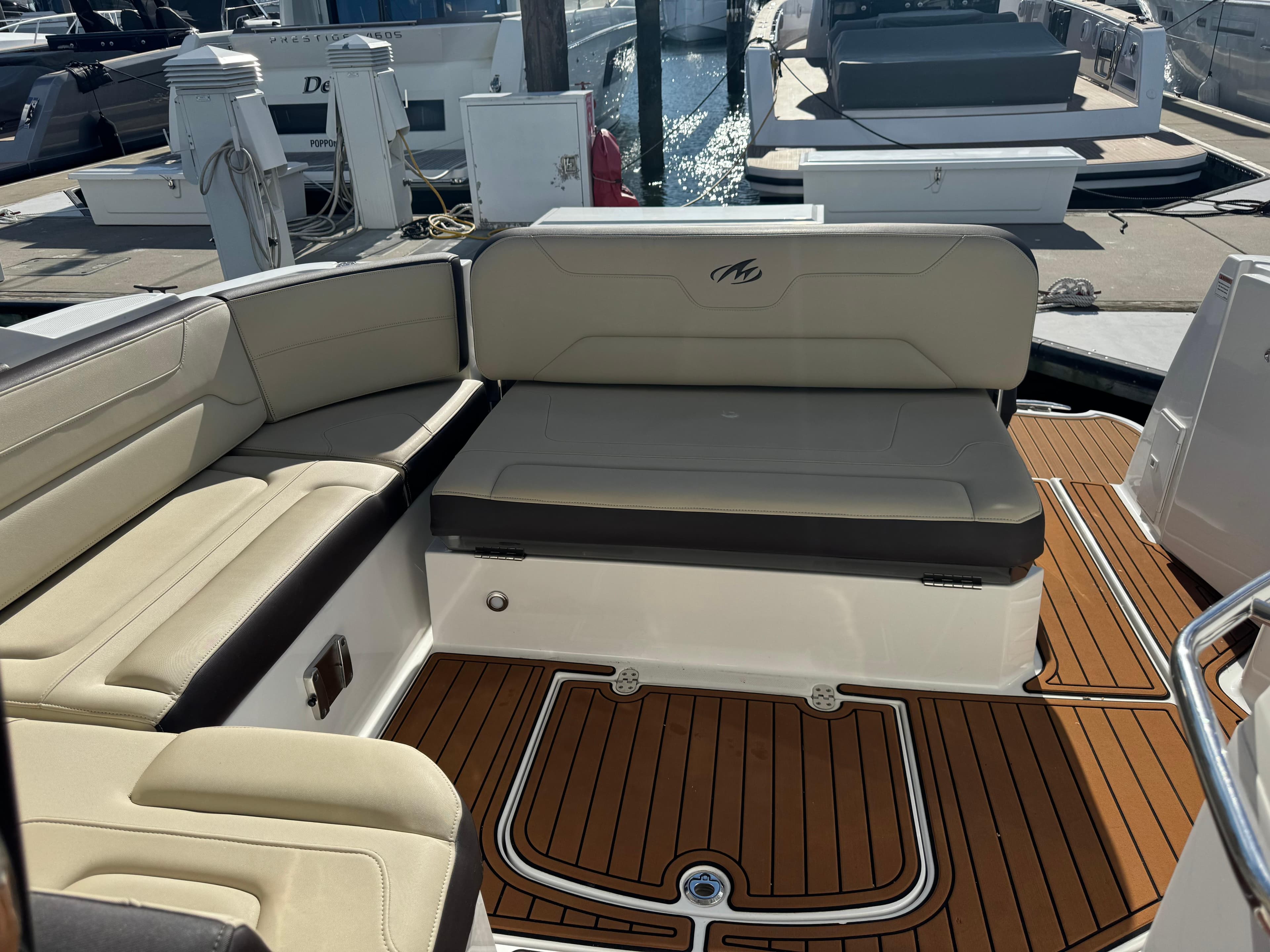 2018 Monterey 335 SY boat interior with beige seating and teak flooring at a marina.