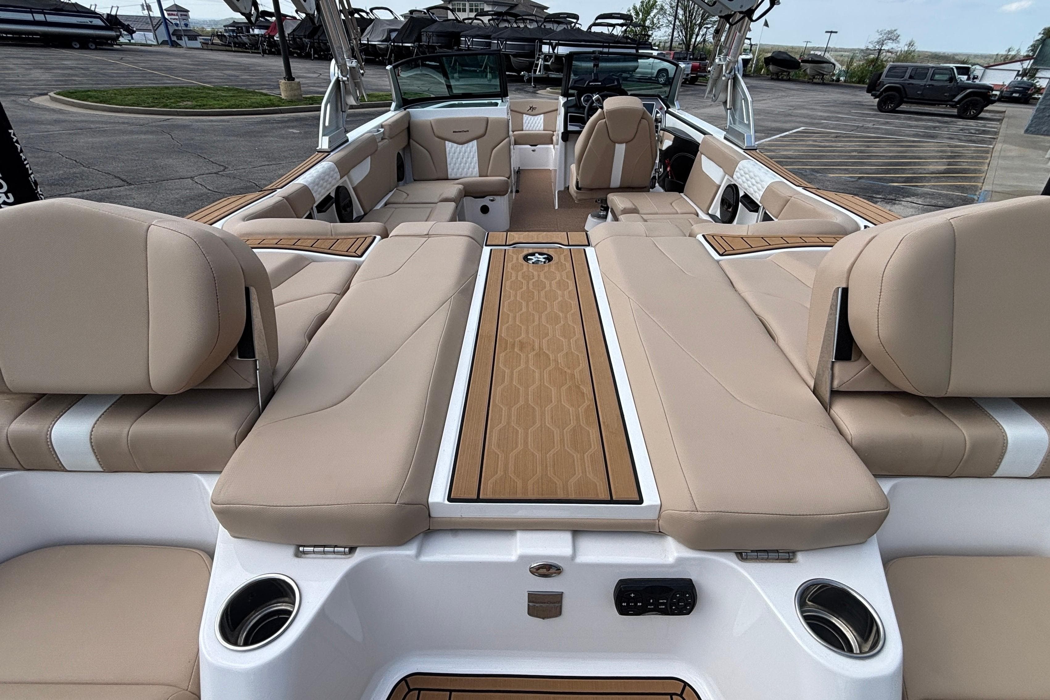 2024 MasterCraft XT24 boat interior with beige seating and wood accents.