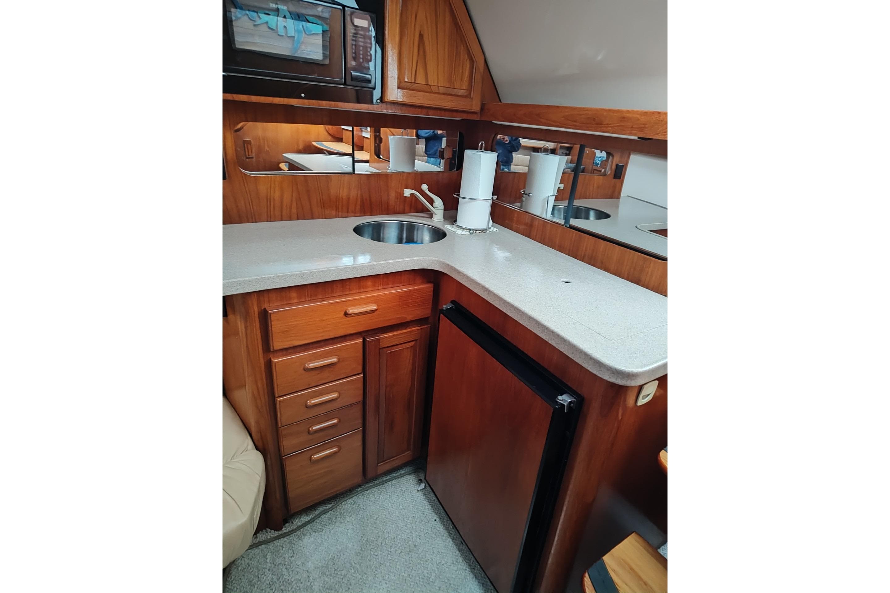 1998 Luhrs 36 SX Open yacht kitchen with wood cabinetry and compact appliances.