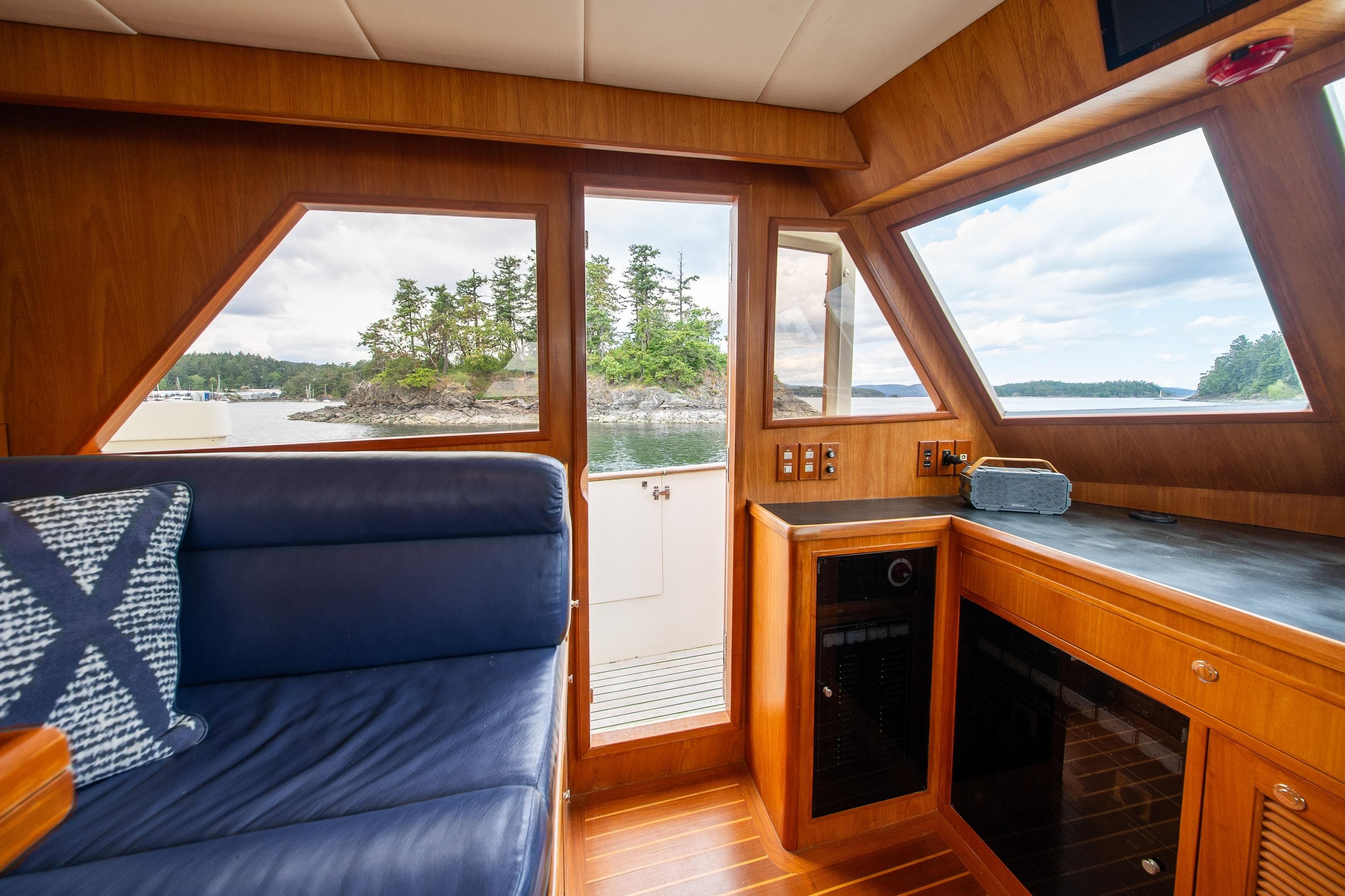Interior of 2000 Grand Alaskan Pilothouse Trawler with scenic ocean view through windows.