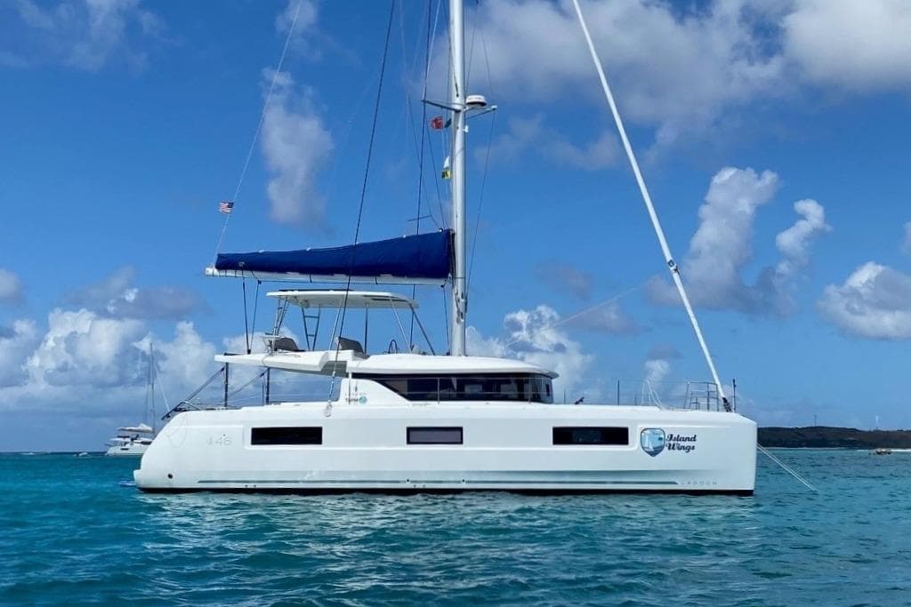 2023 Lagoon 46 catamaran sailing on clear blue waters under a bright sky.