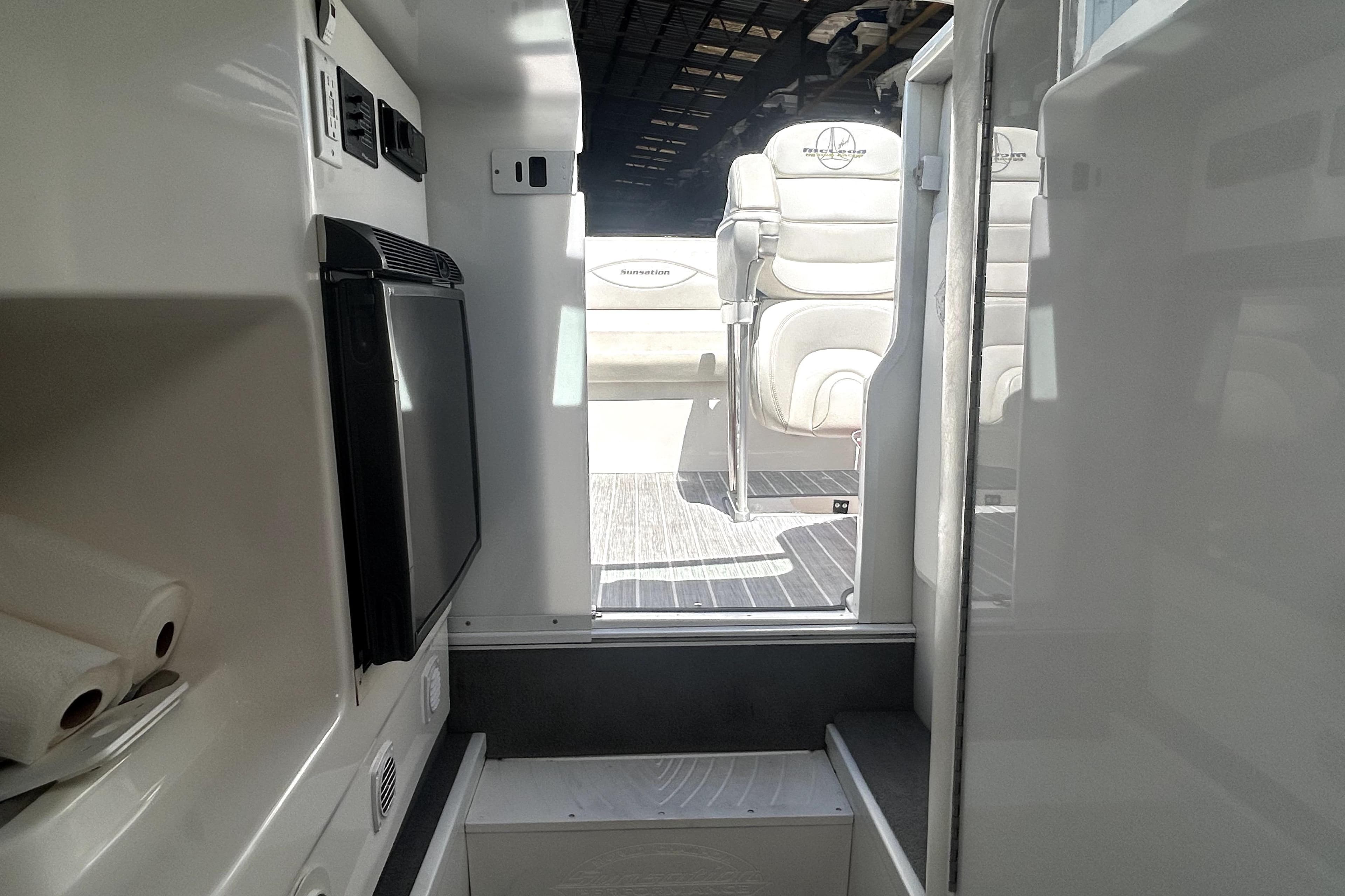 Interior view of 2007 Sunsation 32 Dominator boat, featuring seating and compact amenities.