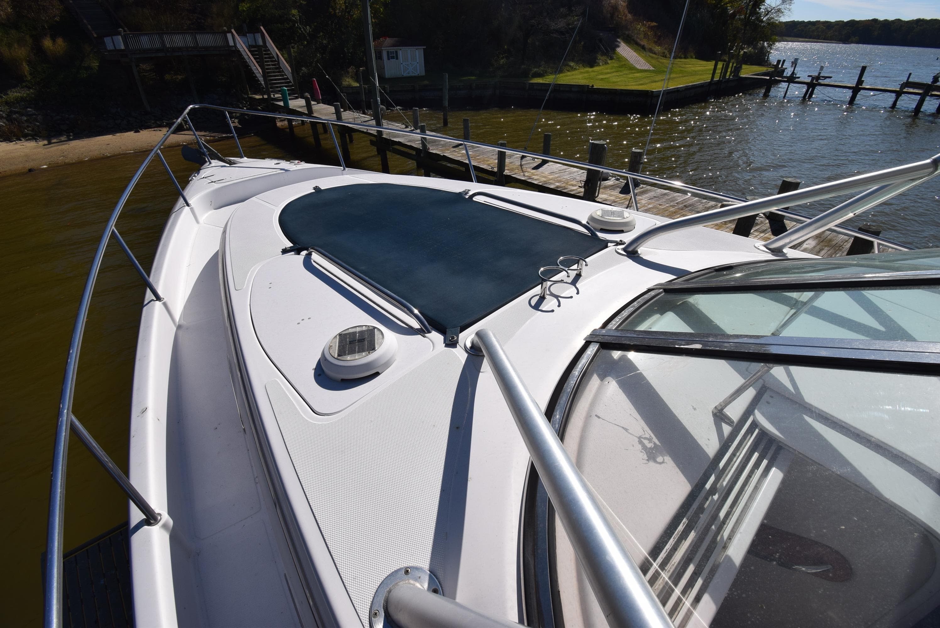 2005 Donzi 38 ZSF boat docked by a scenic waterfront.