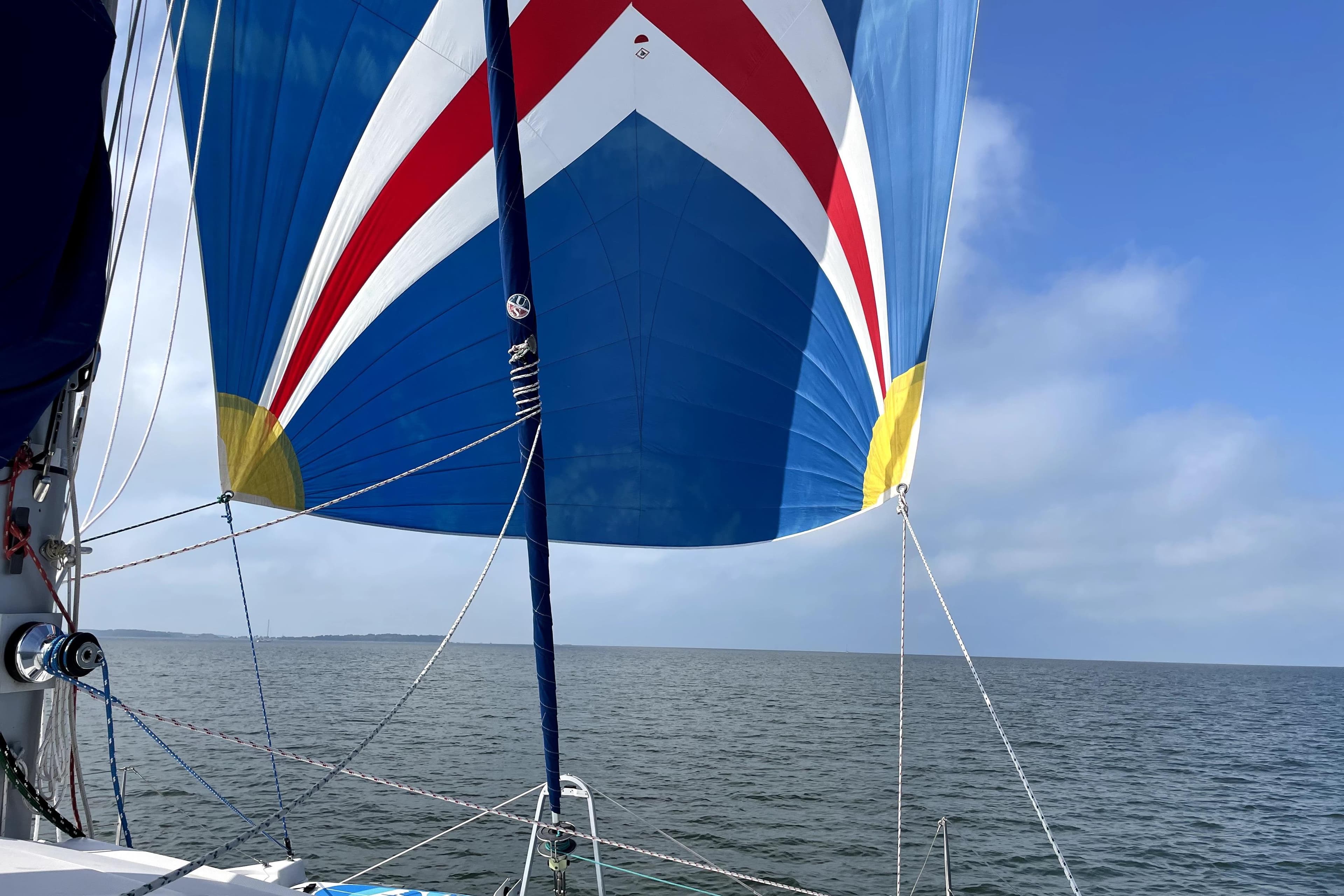 Colorful sail on 2010 Leopard 38 catamaran against blue sky and sea.