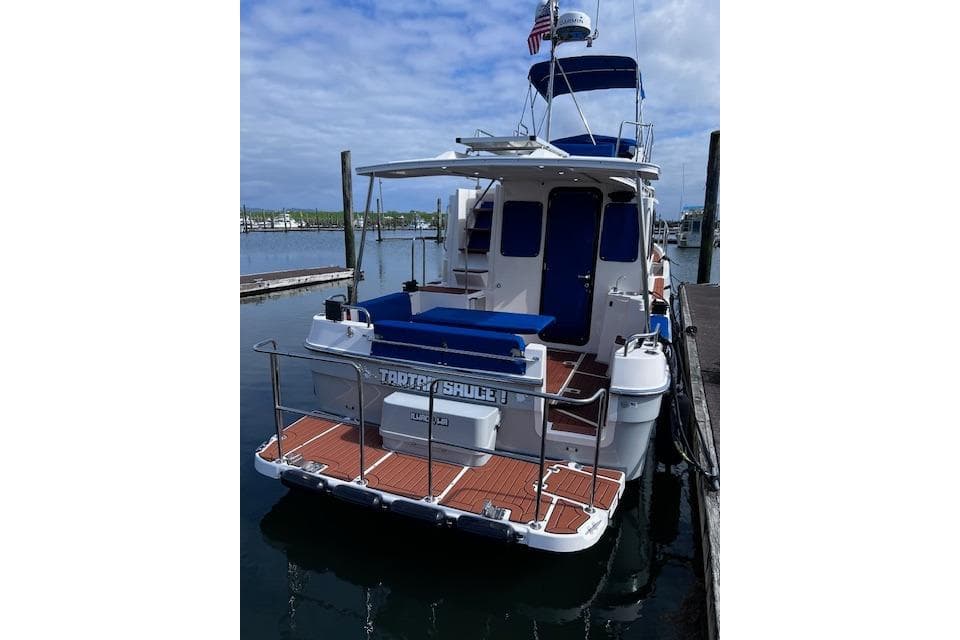 2021 Ranger Tugs R-31 CB docked, featuring a spacious deck and blue accents.