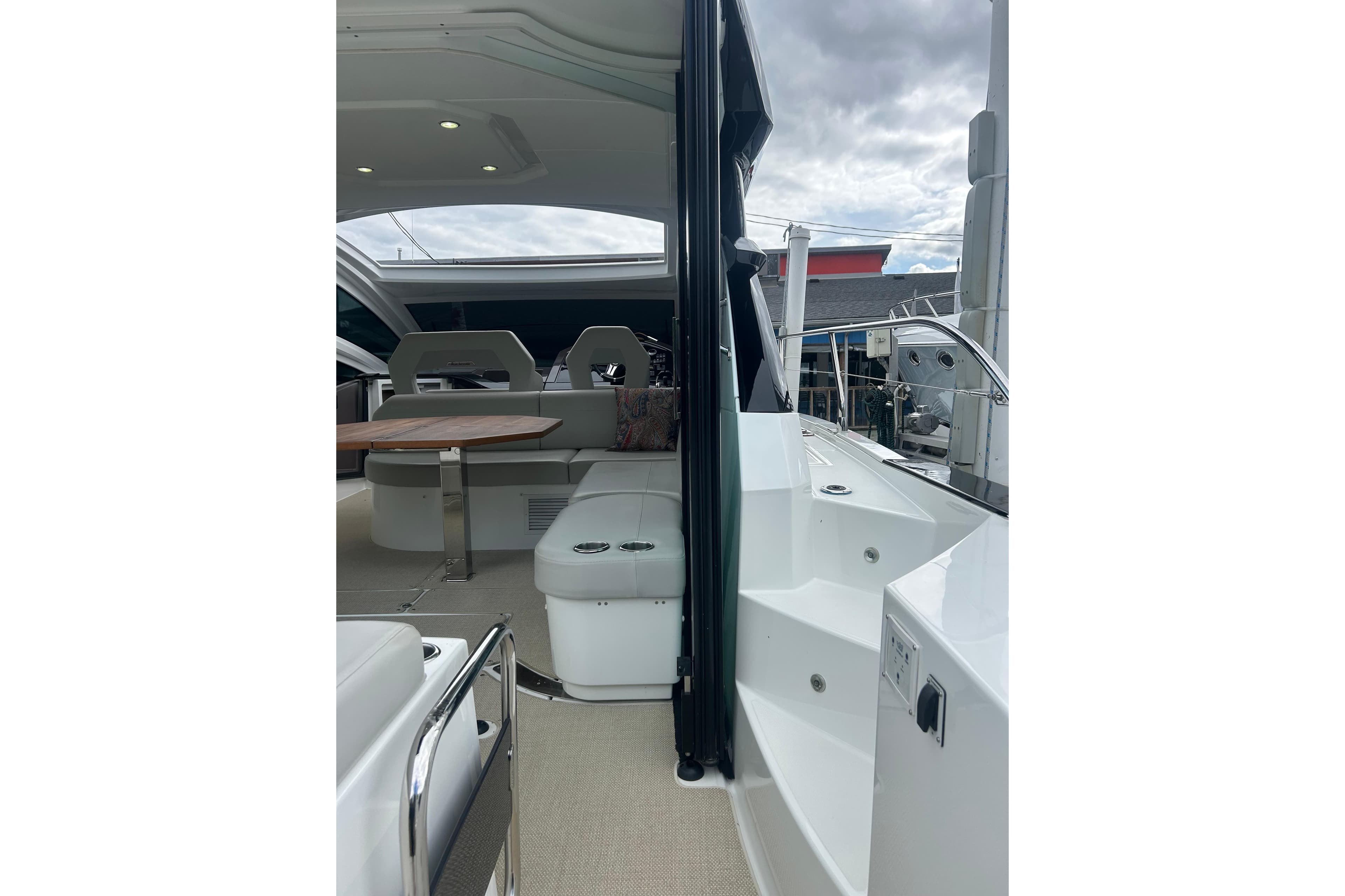 2019 Beneteau Gran Turismo 46 yacht interior with seating and table, under cloudy sky.