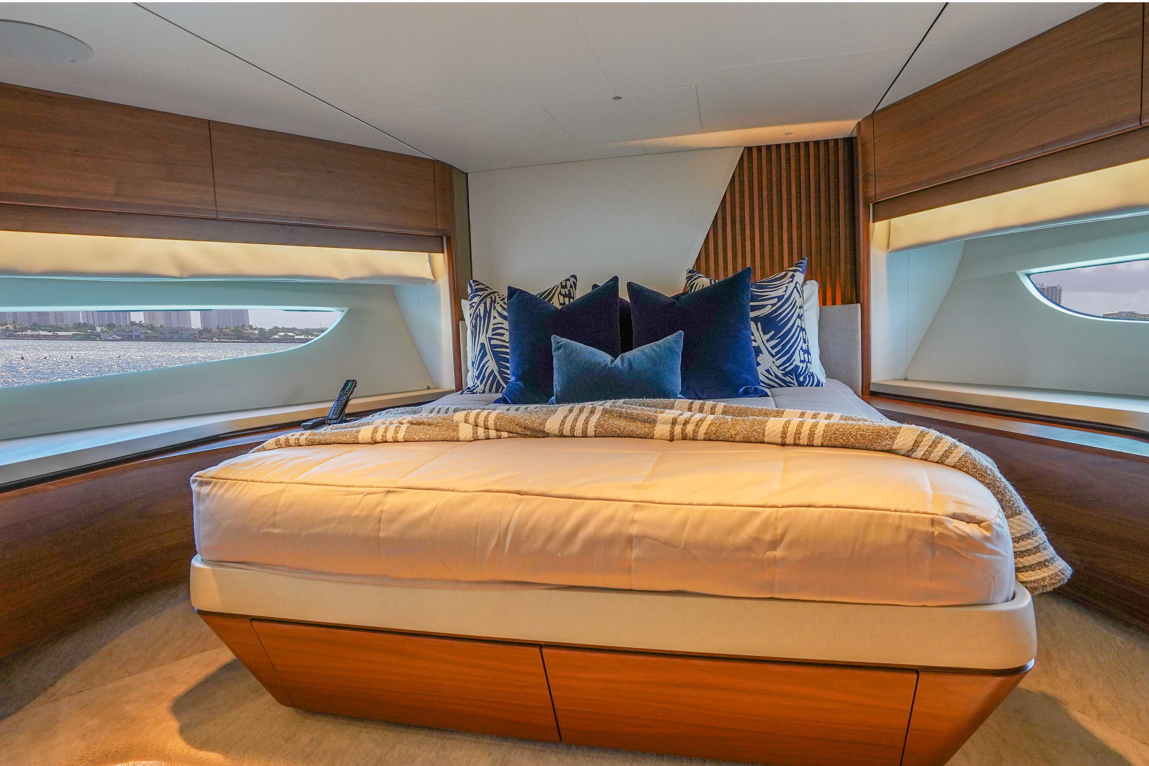 Luxurious bedroom interior of 2021 Princess Y85 yacht with elegant bedding and scenic windows.