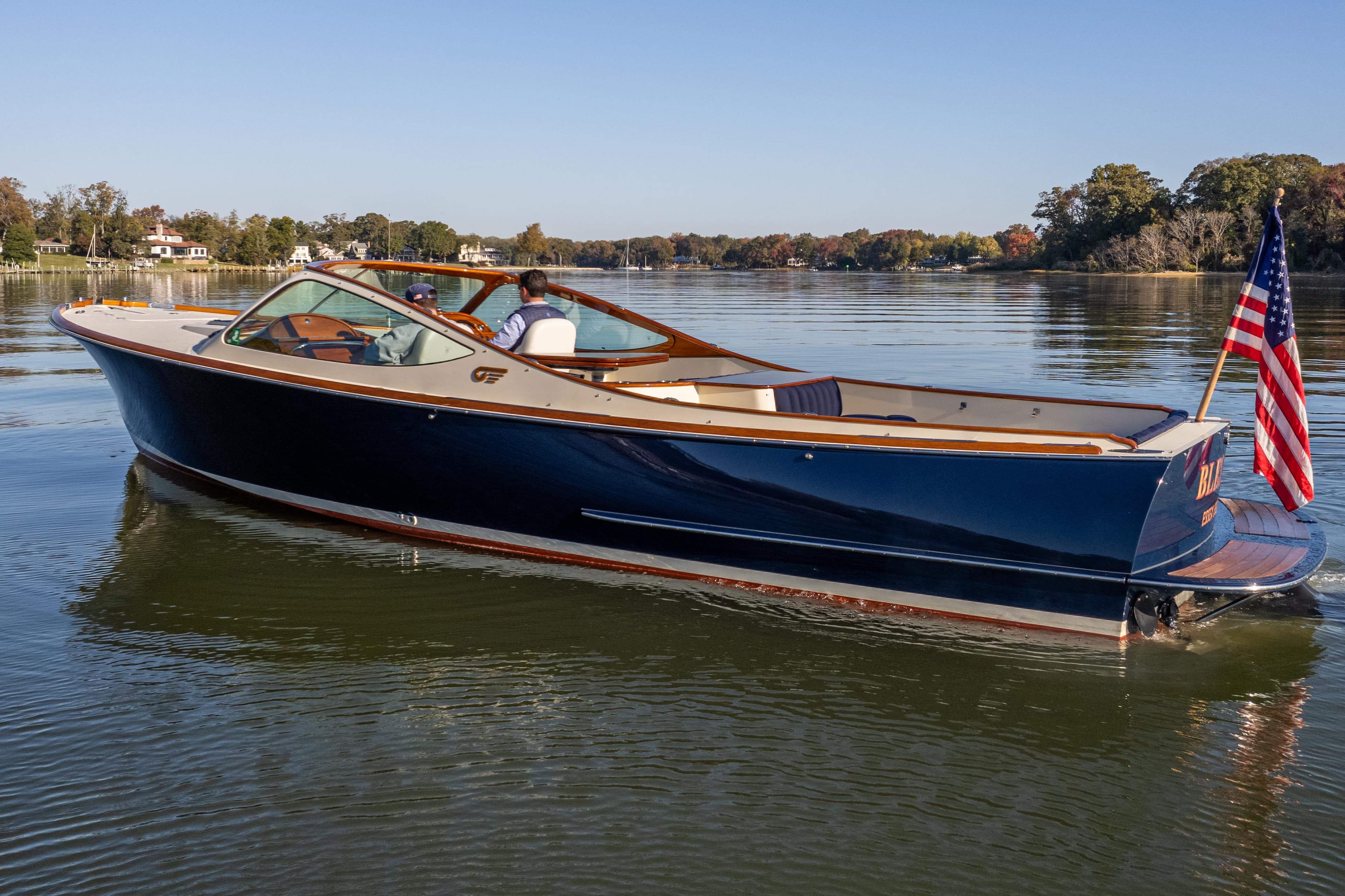 2003 Hinckley Talaria 29 Runabout on calm water, featuring sleek design and American flag.
