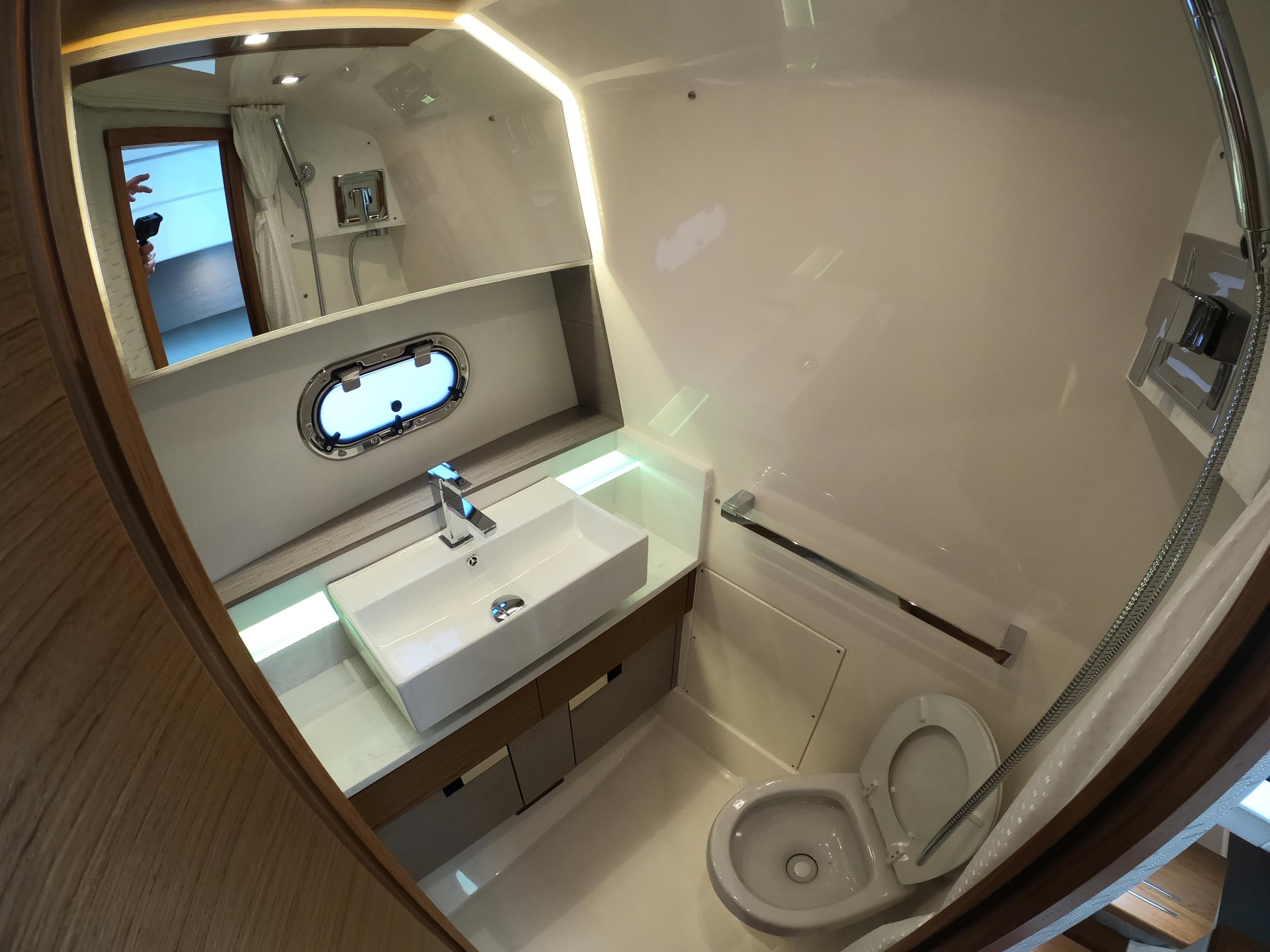 2024 Tiara Yachts 43 LS bathroom with modern sink, toilet, and porthole window.