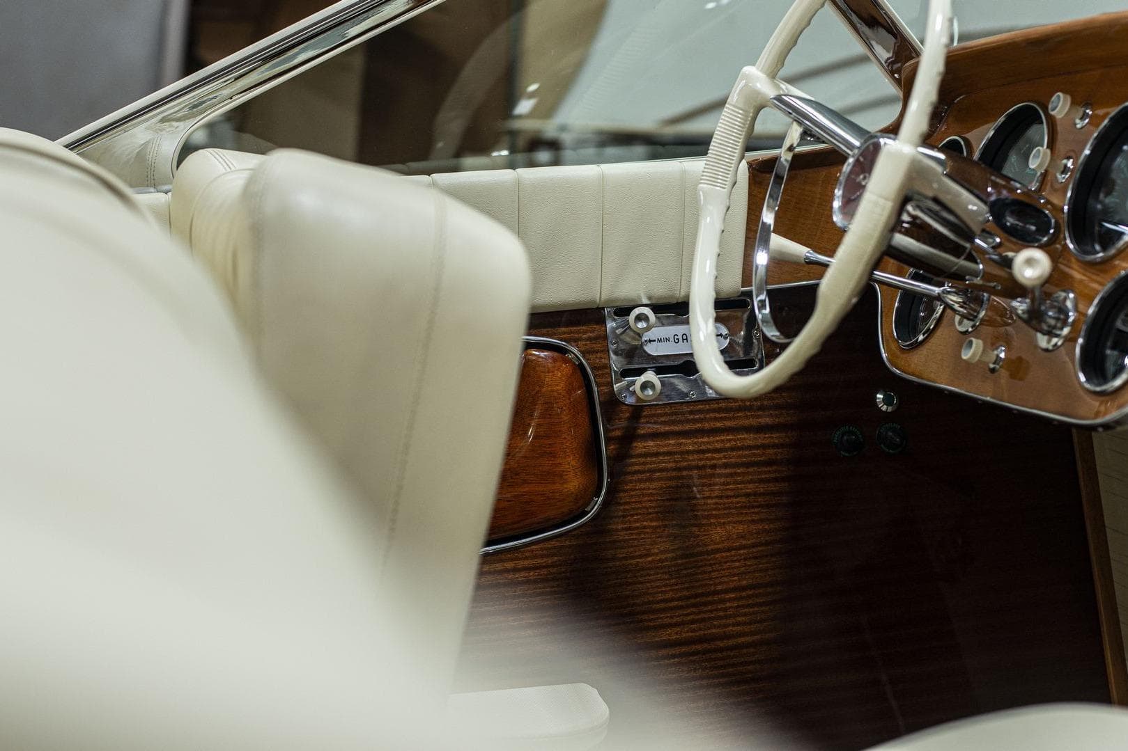 Interior of a 1971 Riva Super Aquarama with classic wooden dashboard and white steering wheel.