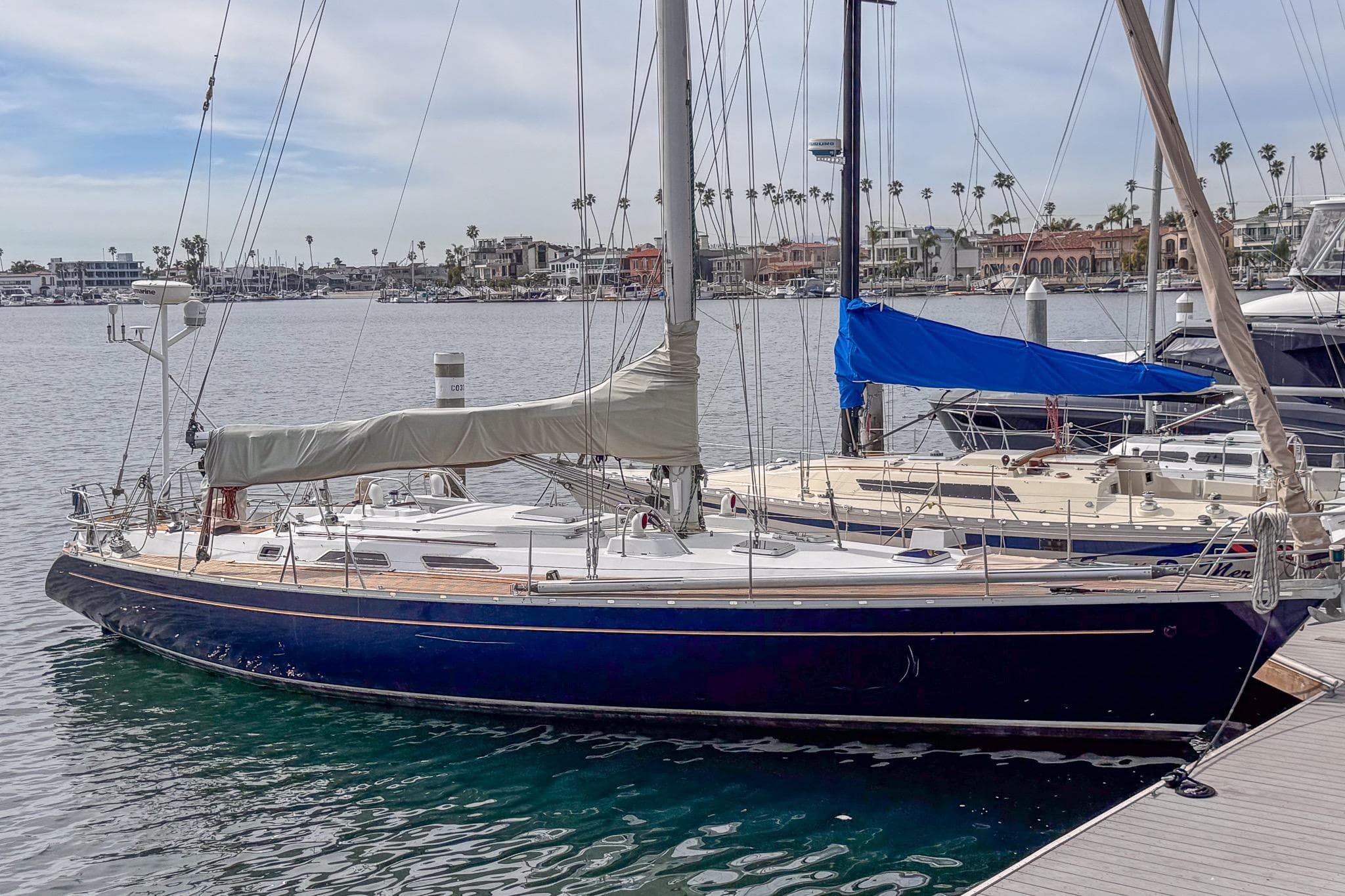 1988 Grand Soleil 46 Jezequel sailboat docked in a marina, calm waters, clear sky.