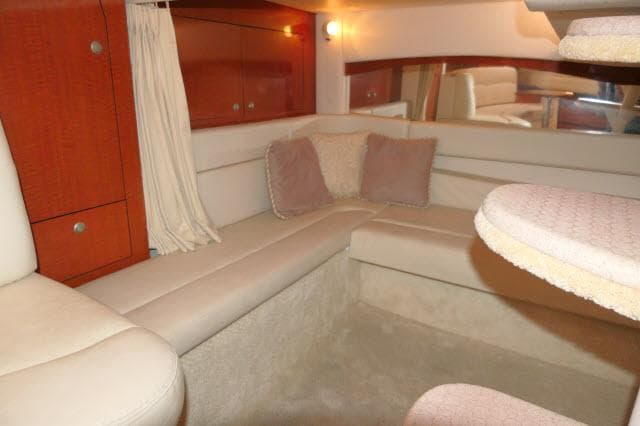 Interior of 2005 Sea Ray 340 Sundancer, featuring cozy seating and elegant wood cabinetry.
