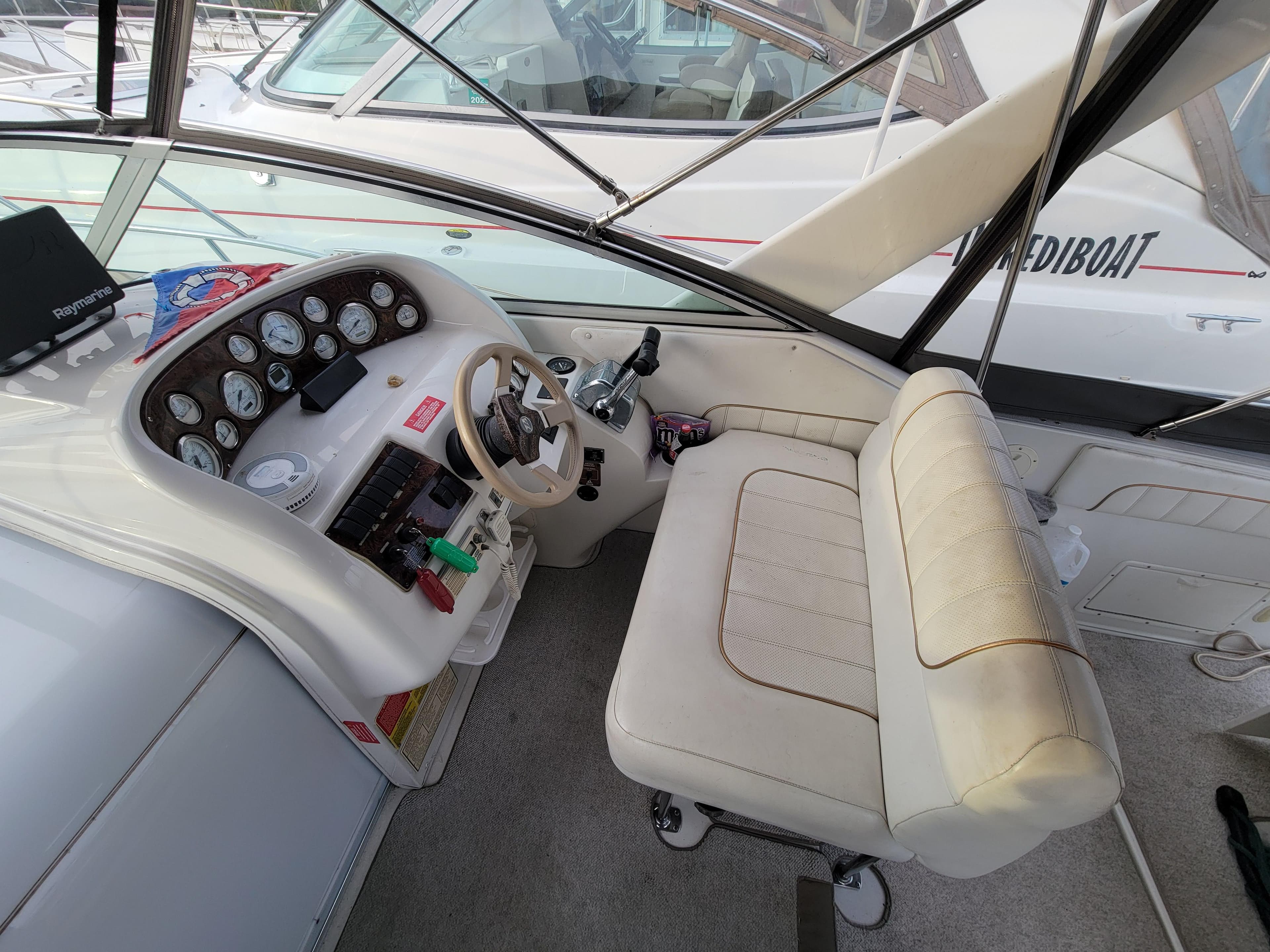 1997 Larson 290 Cabrio boat cockpit with steering wheel and control panel.